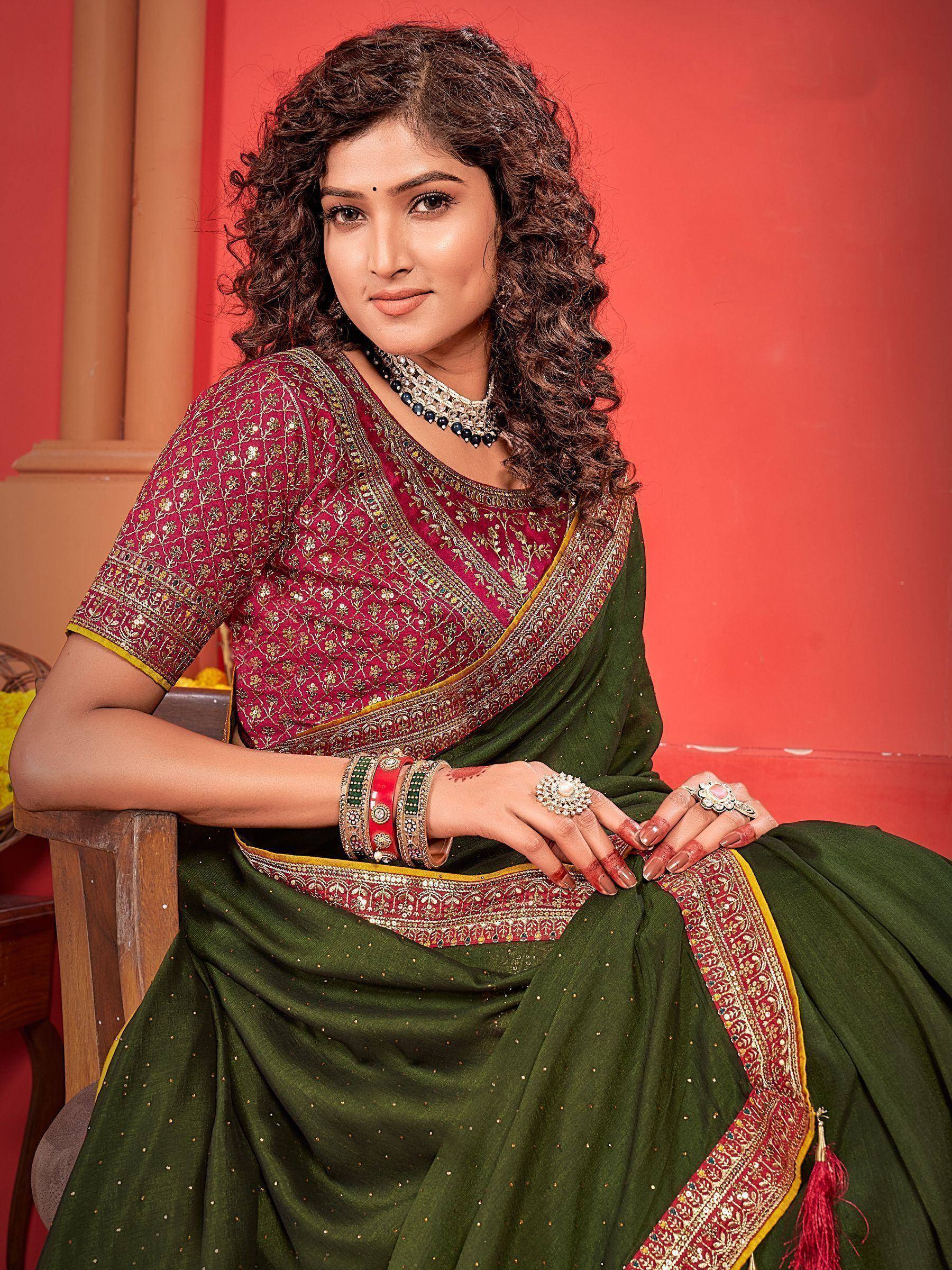Woman in green and maroon embroidered saree with gold detailing, traditional Indian ethnic wear