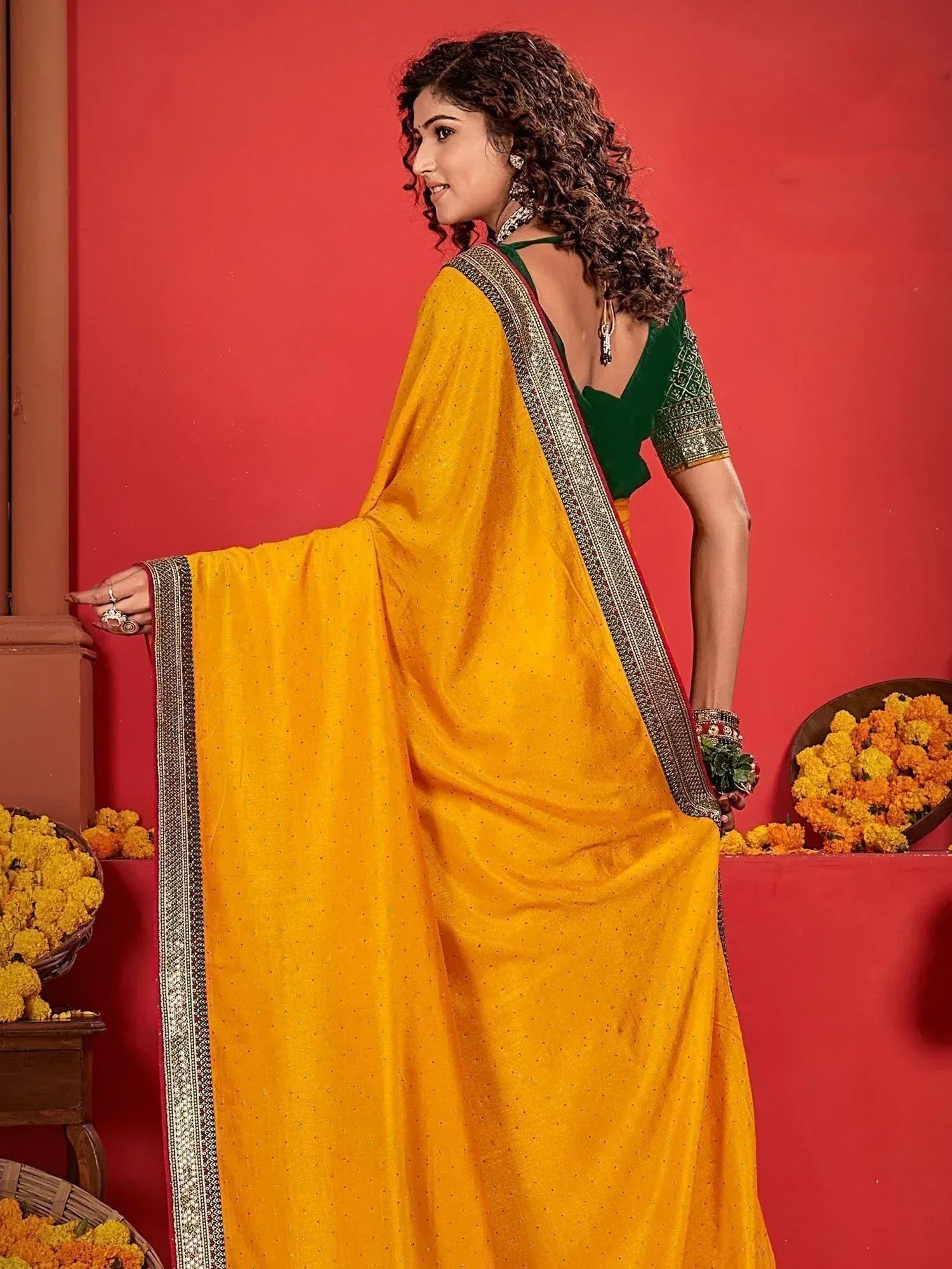 Yellow saree with green blouse, ethnic Indian wear, festive design, marigold flowers backdrop