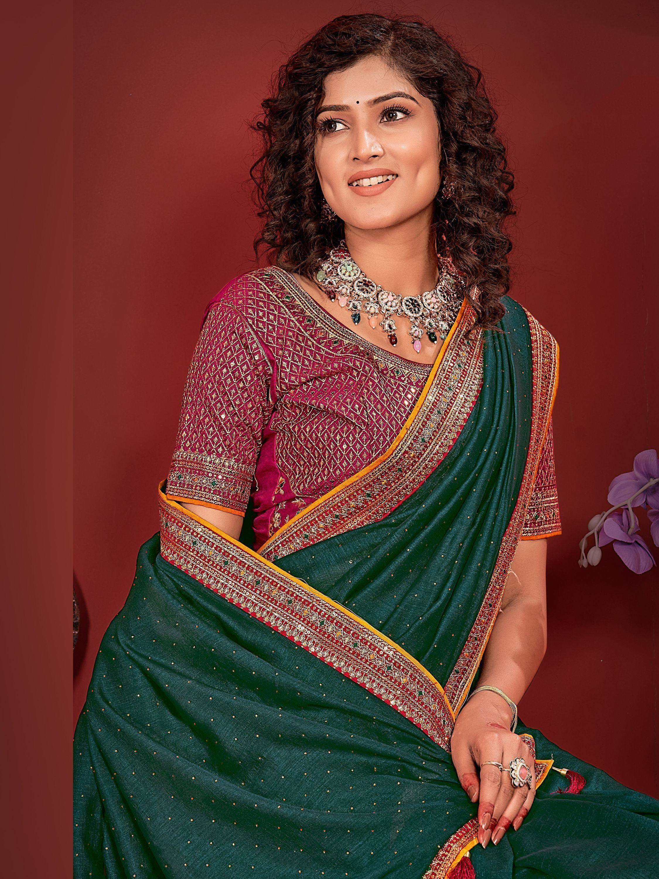 Woman in green and maroon embroidered saree with gold border, traditional Indian ethnic wear