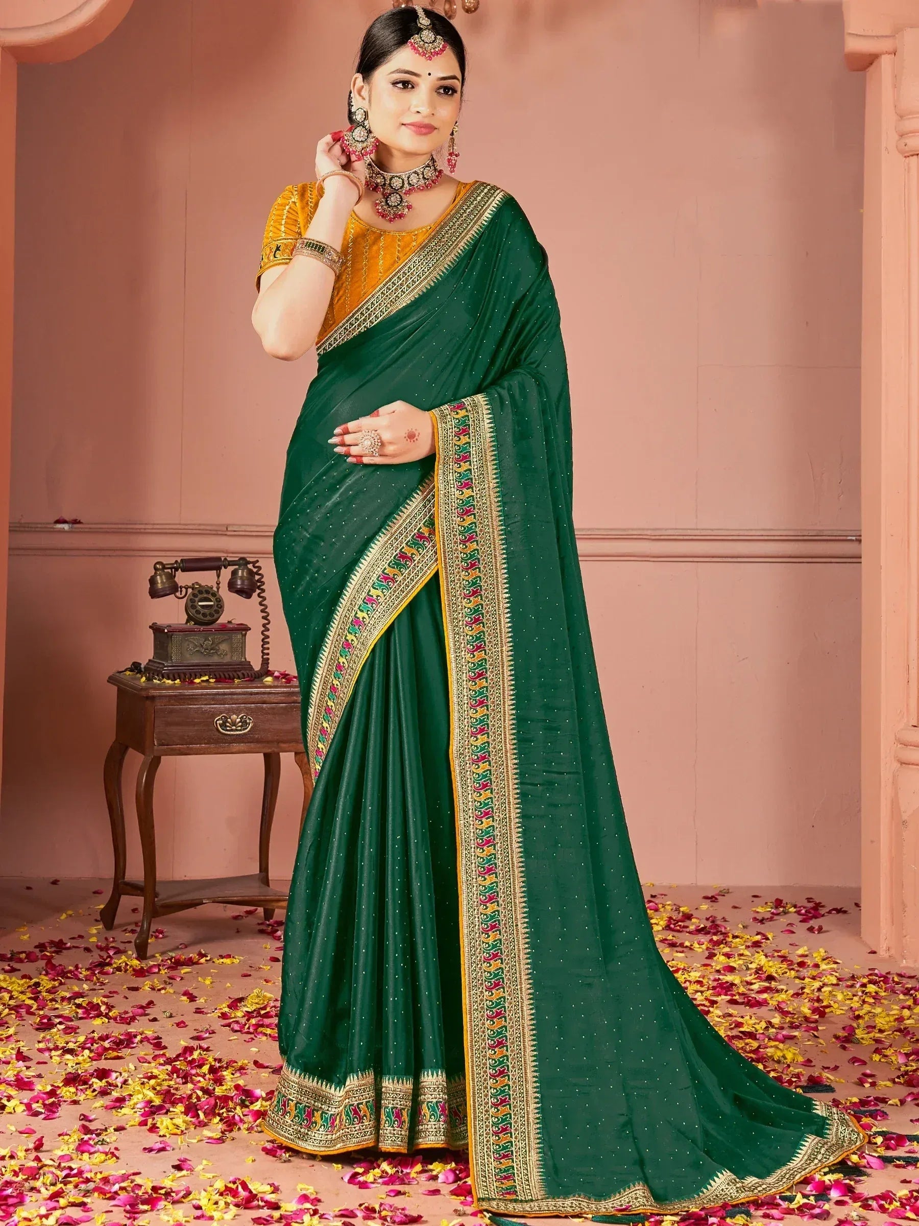 Elegant green saree with golden border and intricate embroidery, paired with a yellow blouse for festive occasions.