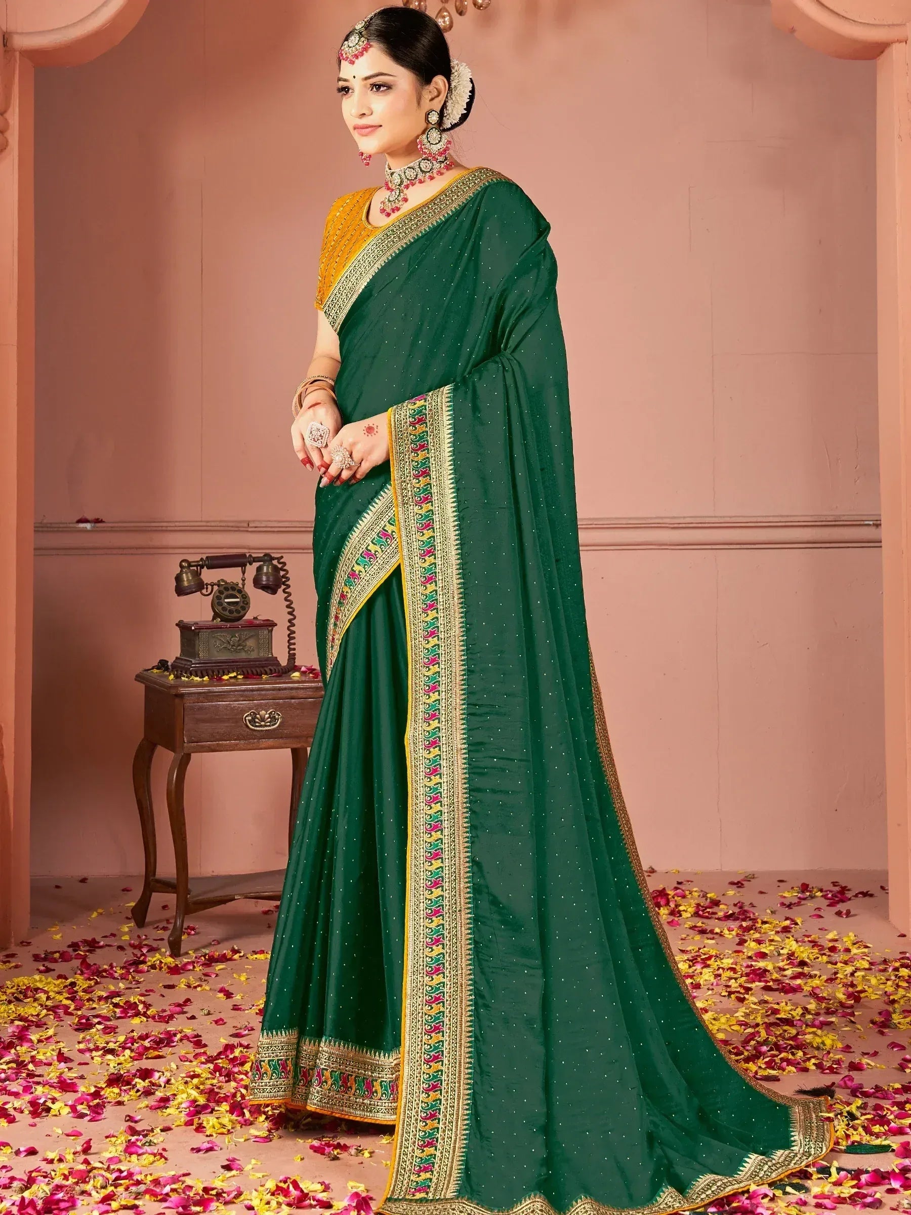 Emerald green saree with golden border and floral embroidery, paired with traditional jewelry