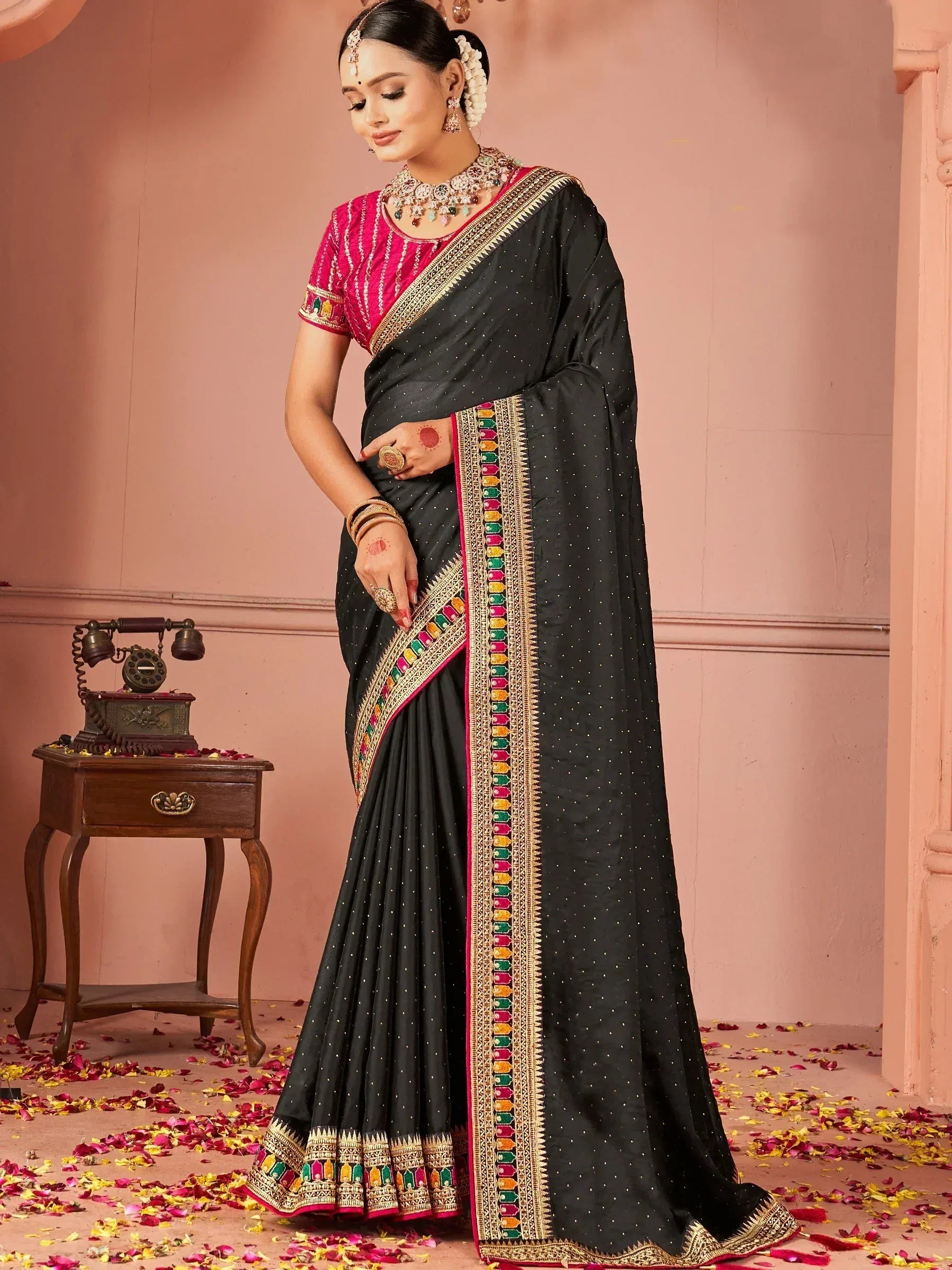 Black saree with colorful embroidery and pink blouse, styled with traditional jewelry for Indian ethnic wear.