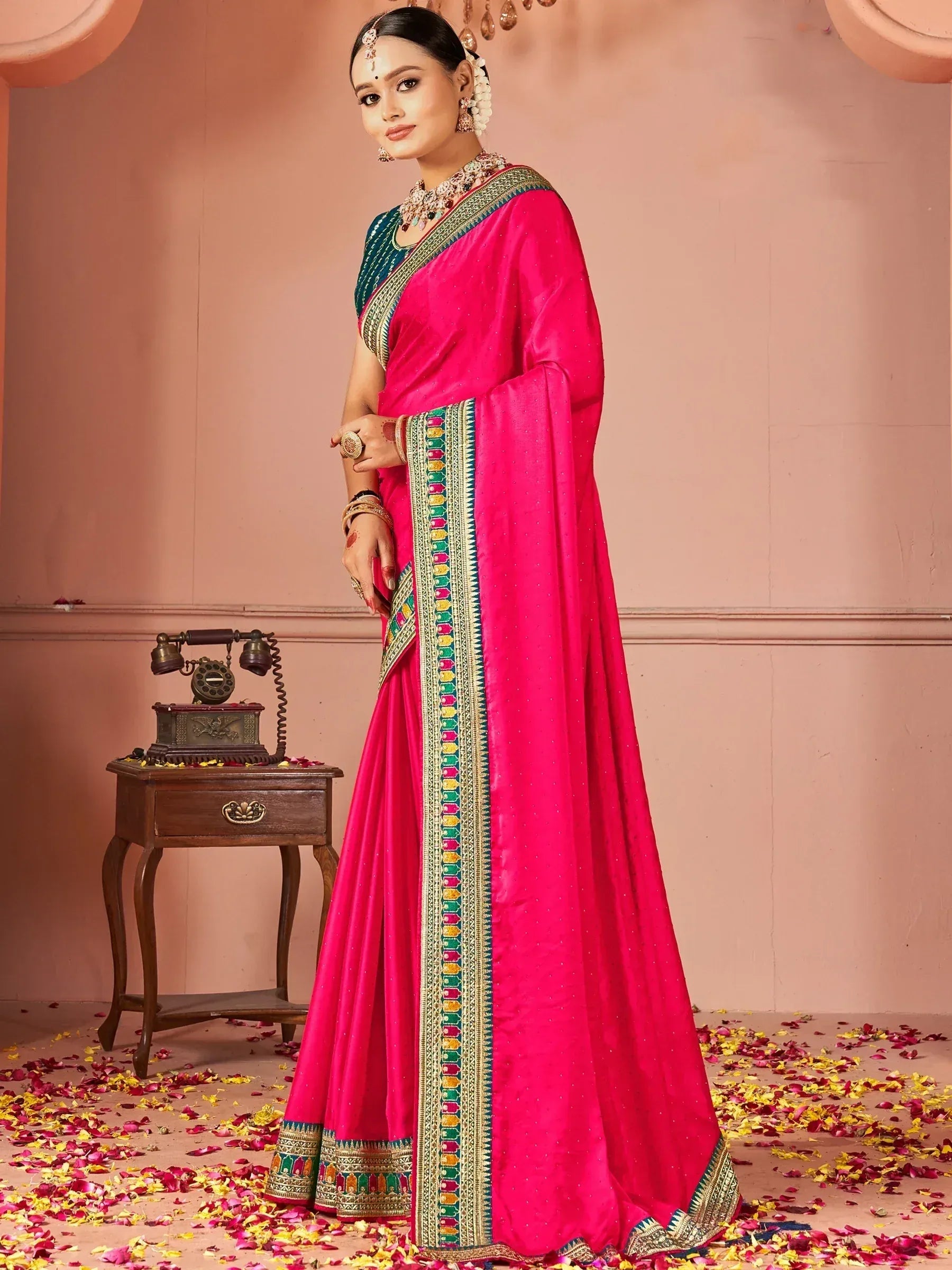 Vibrant pink Indian saree with colorful border, perfect for festive occasions and weddings