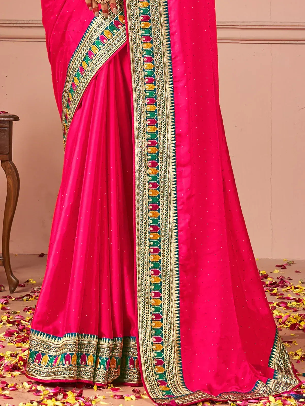Vibrant pink Indian saree with colorful temple border and sequin detailing, perfect for festive occasions.