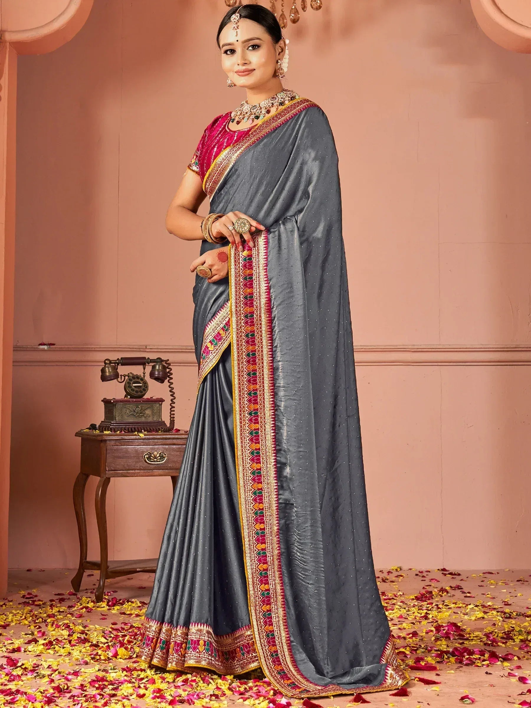 Grey designer saree with colorful embroidered border, paired with pink blouse, perfect for Indian ethnic occasions.