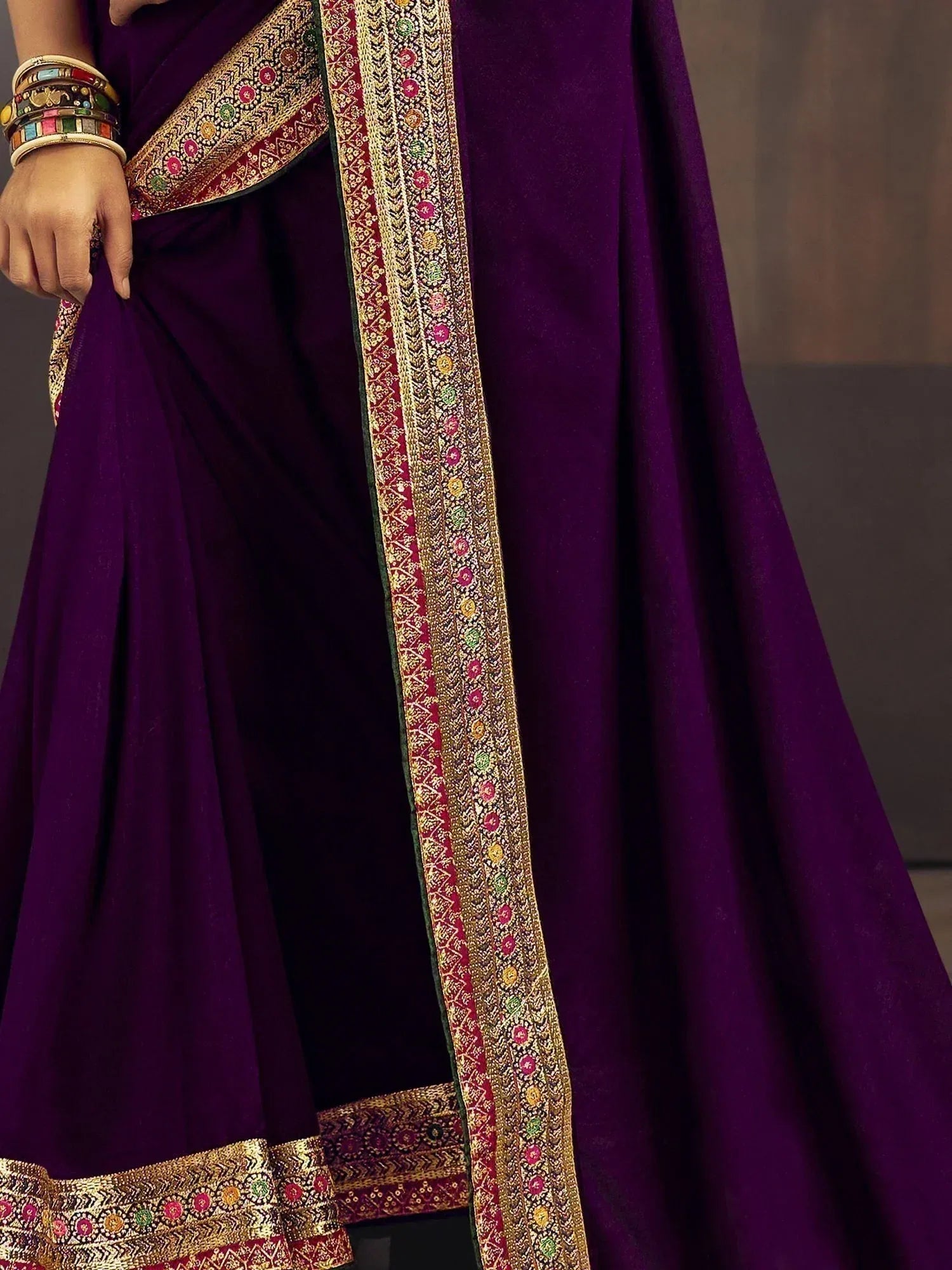 Rich purple Indian saree with intricate gold and colorful embroidery, perfect for ethnic occasions.