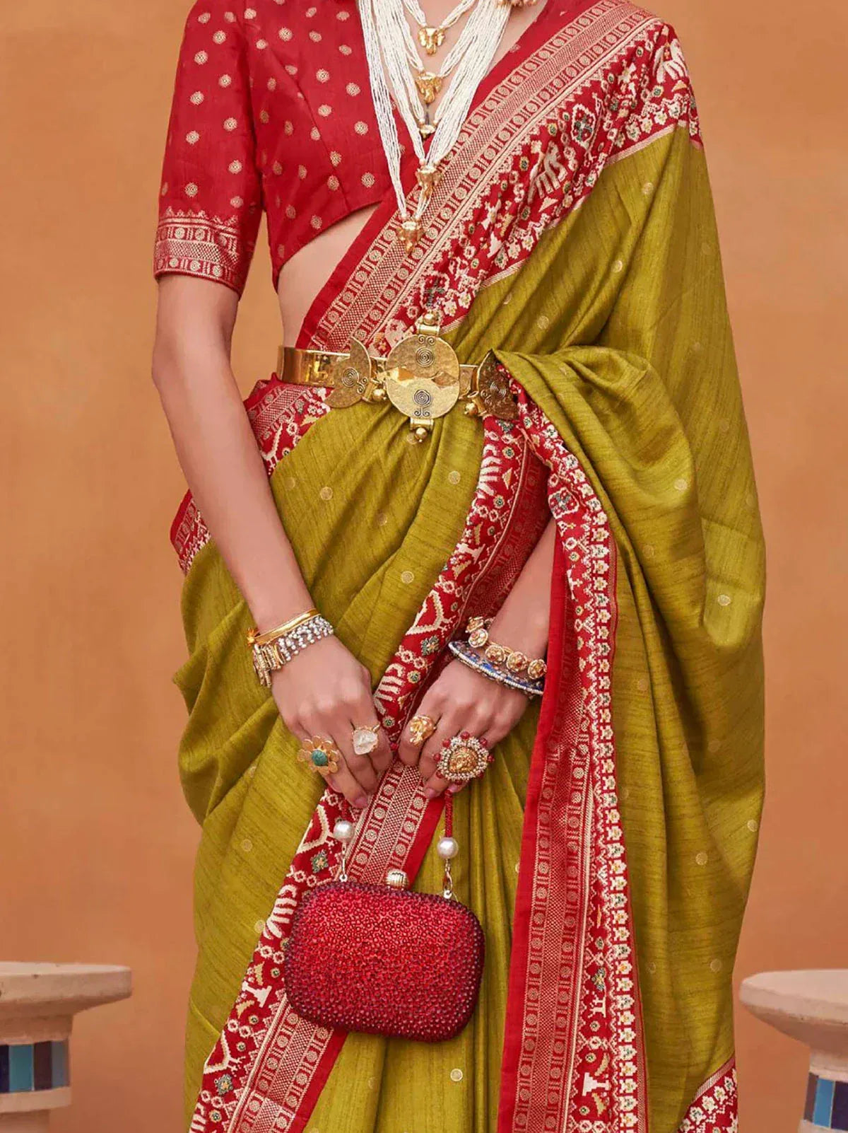 Woman in vibrant pink ethnic saree with gold jewelry, traditional Indian attire for weddings or festivals