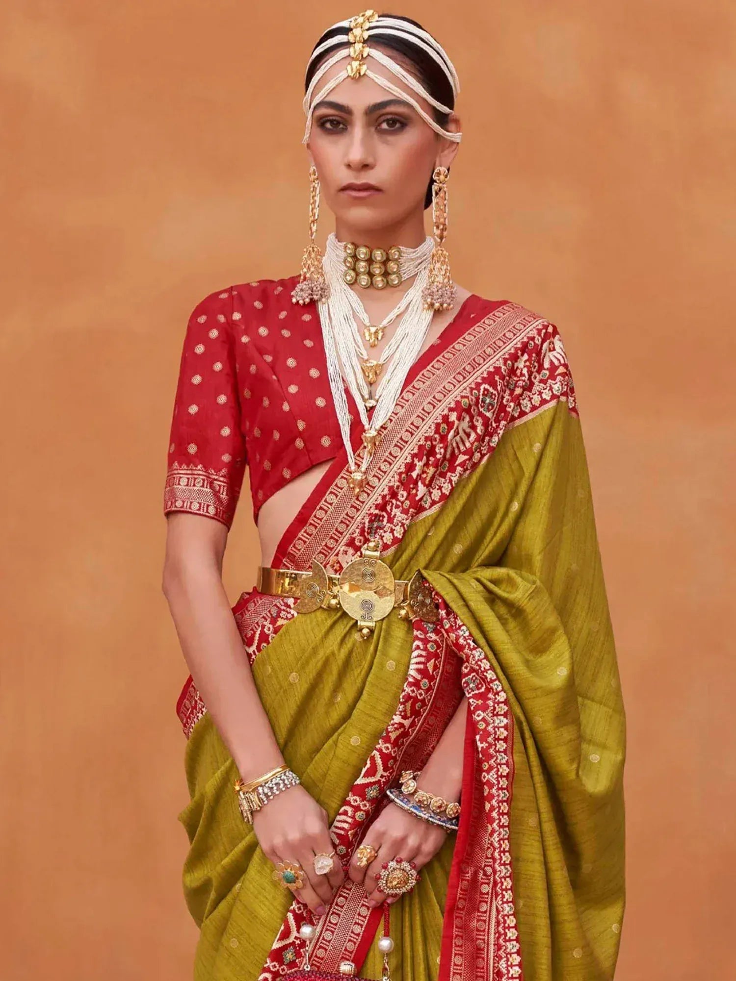 Red and olive green ethnic saree with gold jewelry, traditional Indian bridal wear