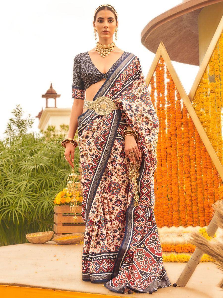 Woman in printed ethnic saree with gold jewelry, marigold decor, traditional Indian attire