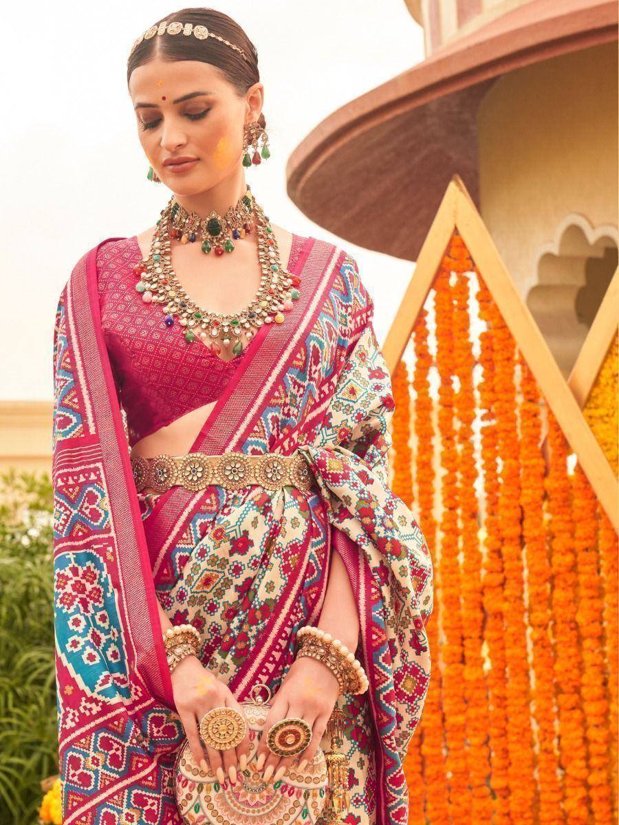 Woman in vibrant Indian saree with intricate patterns, traditional jewelry, and festive marigold backdrop