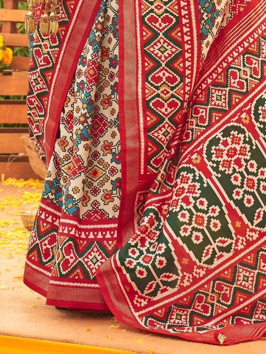 Vibrant red and green ethnic saree with intricate geometric patterns, perfect for festive occasions.