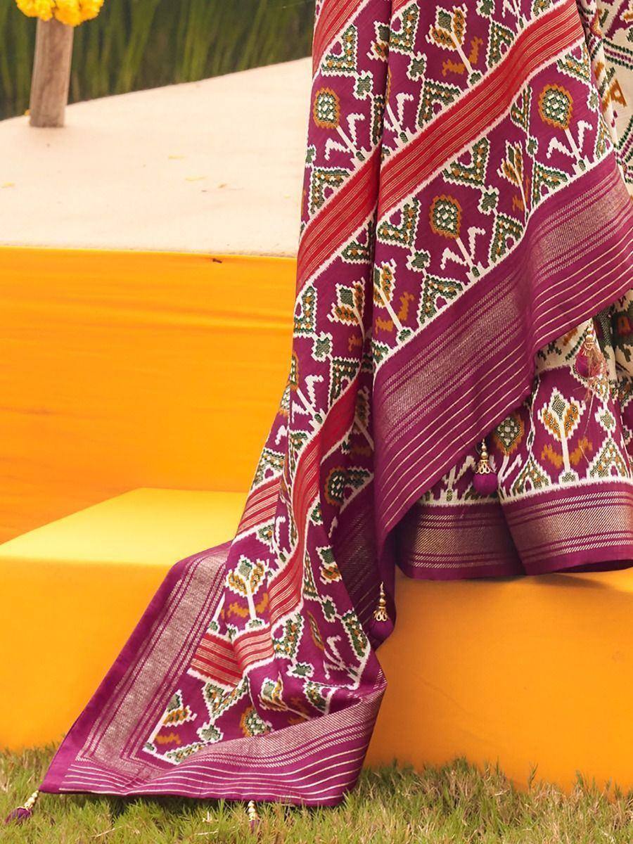 Purple ethnic saree with intricate geometric print and gold border, styled outdoors on yellow steps