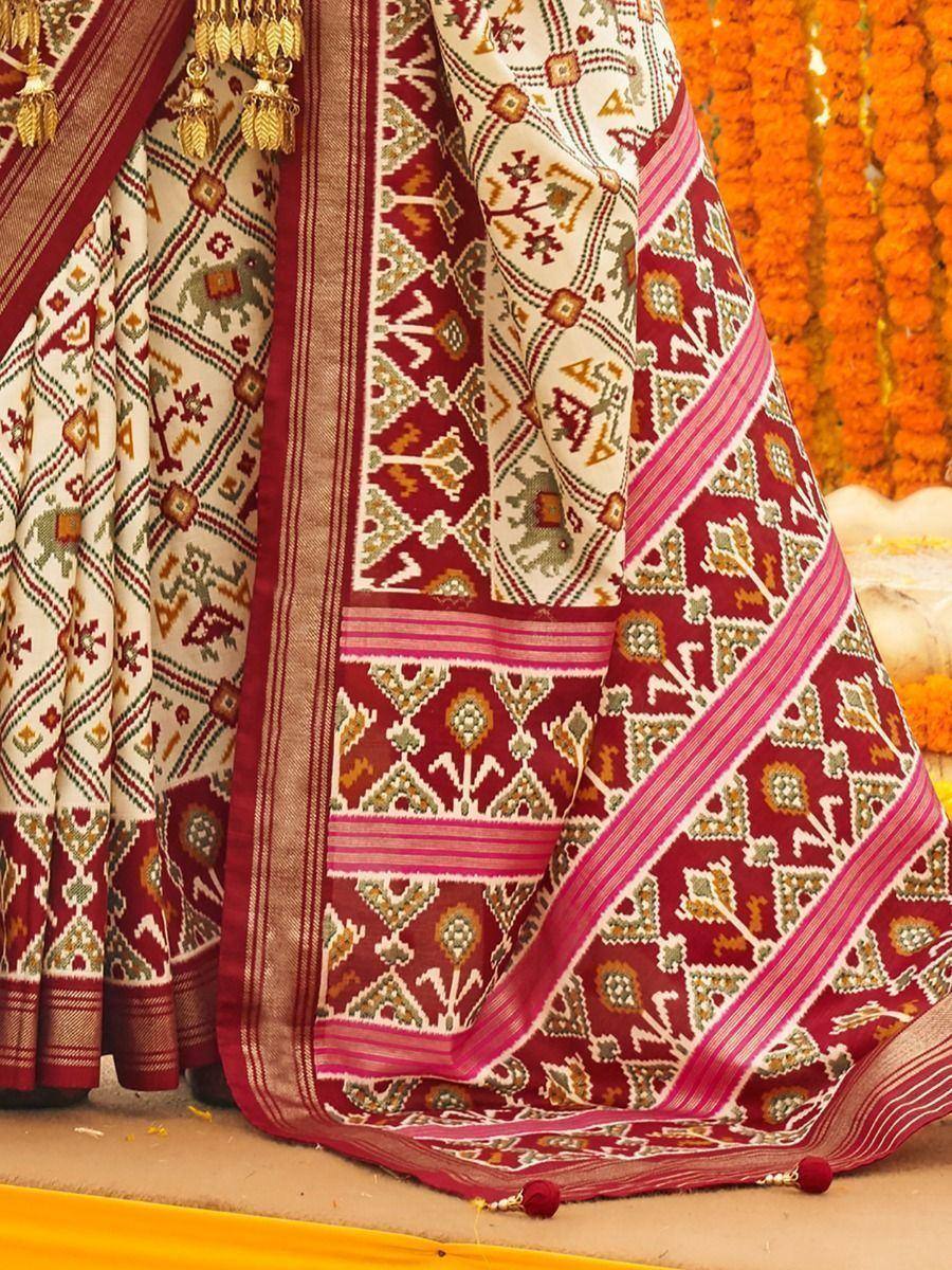 Ethnic Indian saree with intricate geometric and elephant motifs in maroon, cream, and pink, perfect for festive occasions.