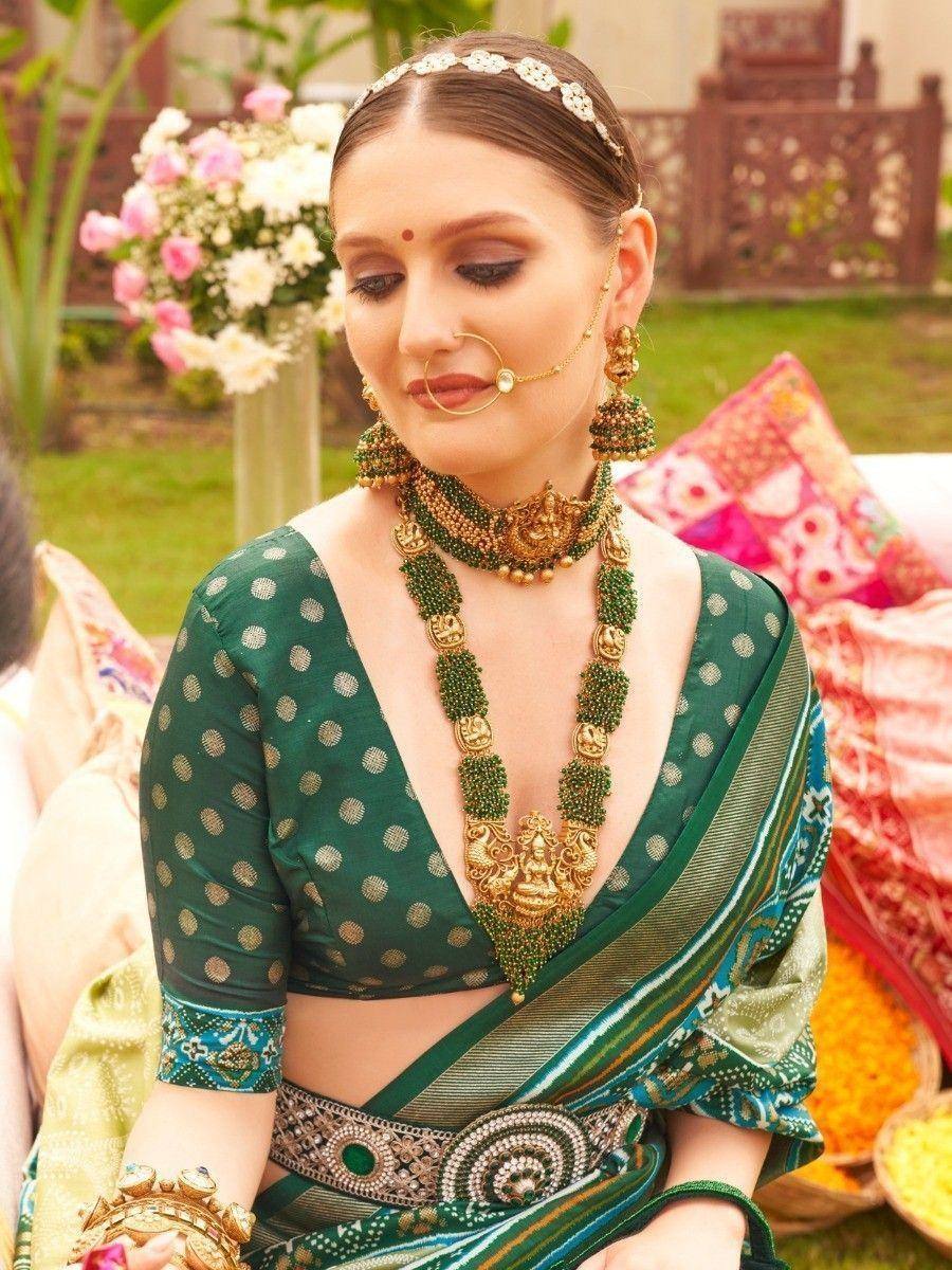 Woman in green polka dot saree with gold jewelry, traditional Indian ethnic wear for weddings