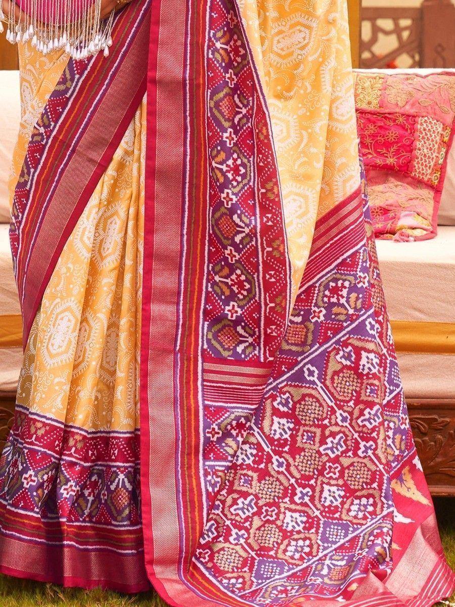 Vibrant yellow and red ethnic saree with intricate geometric patterns and bold borders
