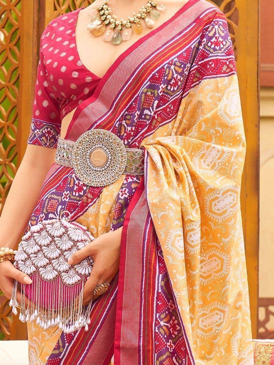 Vibrant ethnic saree with intricate patterns, paired with a designer belt and embellished clutch.