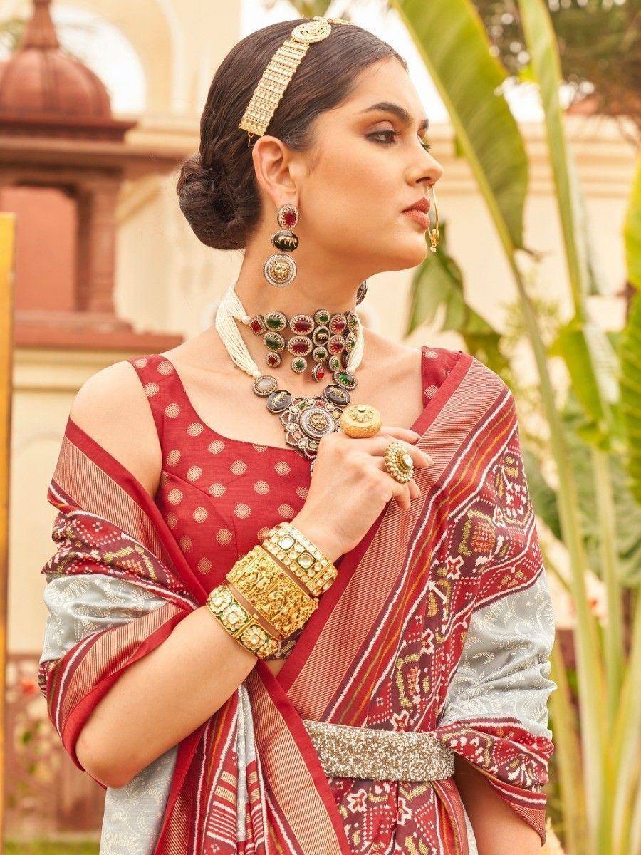 Woman in red and silver ethnic saree with traditional jewelry, perfect for Indian weddings or festivals