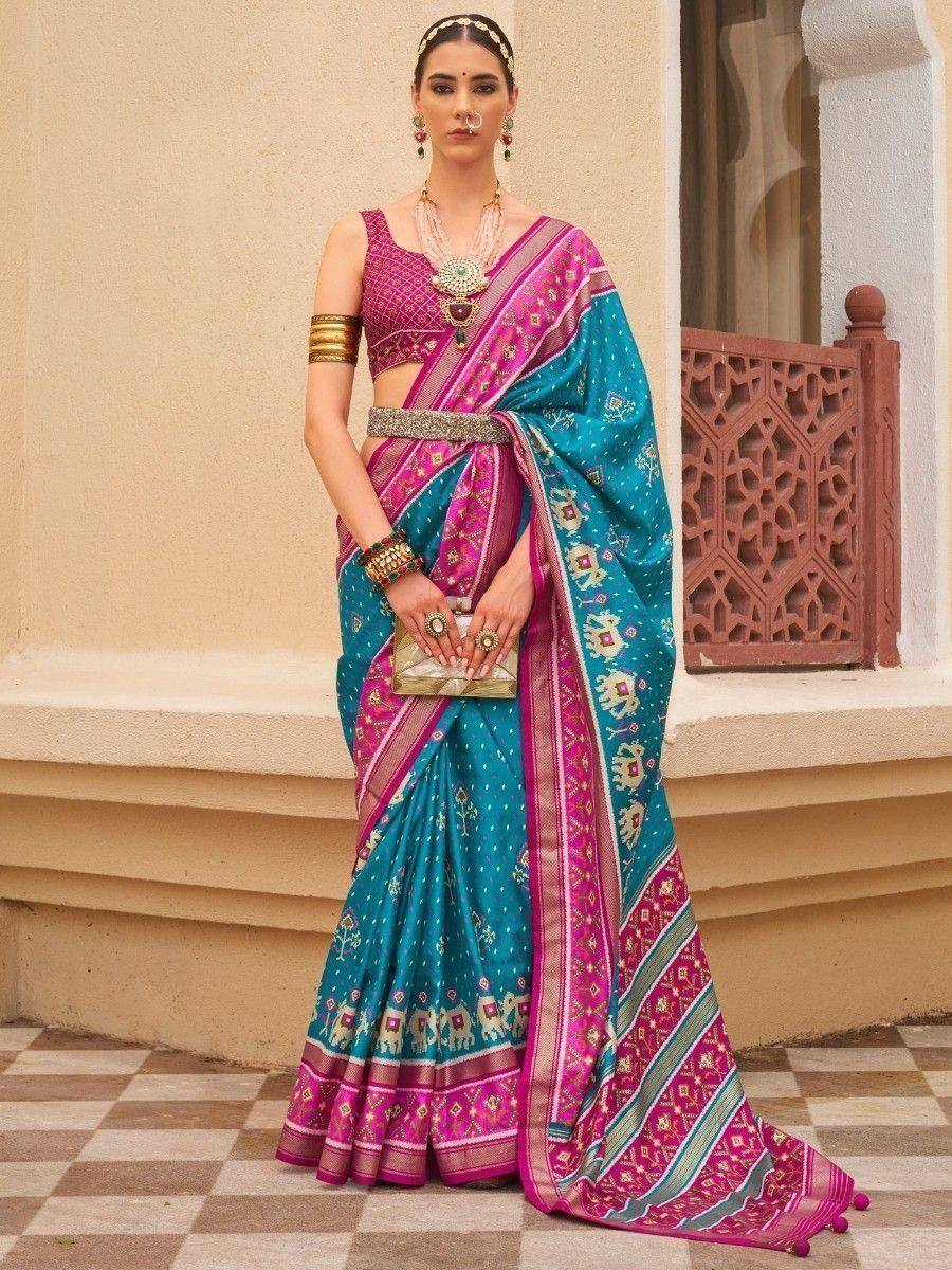 Teal and pink ethnic saree with elephant print, paired with designer blouse and traditional jewelry