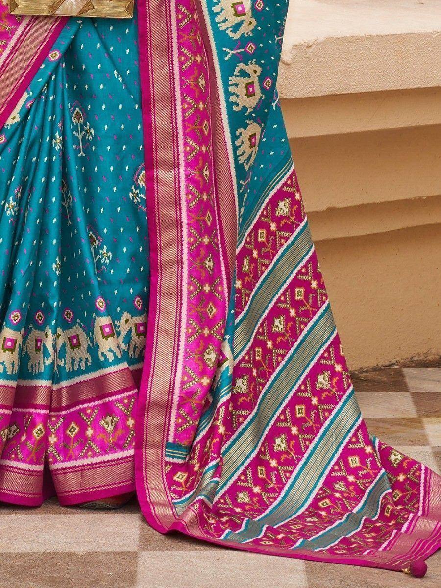 Teal and pink ethnic saree with elephant motifs and intricate border designs, perfect for festive occasions.
