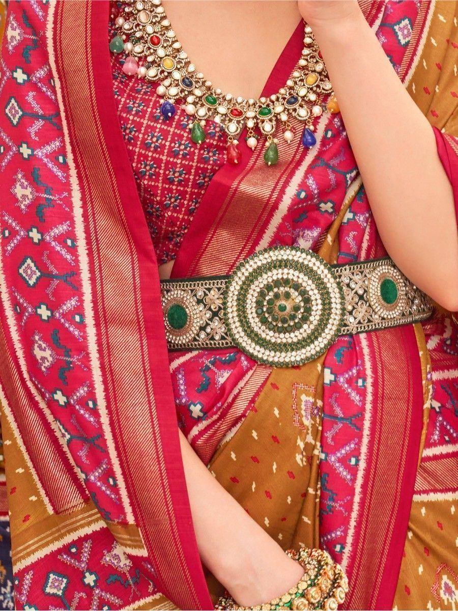 Red and gold ethnic saree with intricate embroidery, statement necklace, and embellished belt for festive occasions