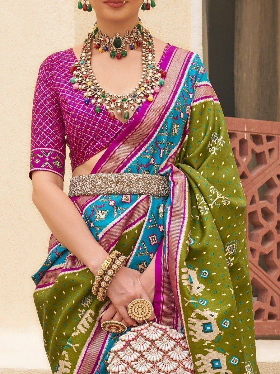 Vibrant Indian saree with pink blouse, green and blue border, paired with statement jewelry for ethnic occasions