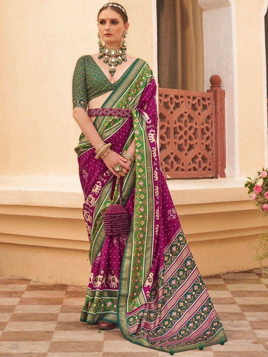 Purple and green printed saree with elephant motifs, paired with matching blouse and traditional jewelry