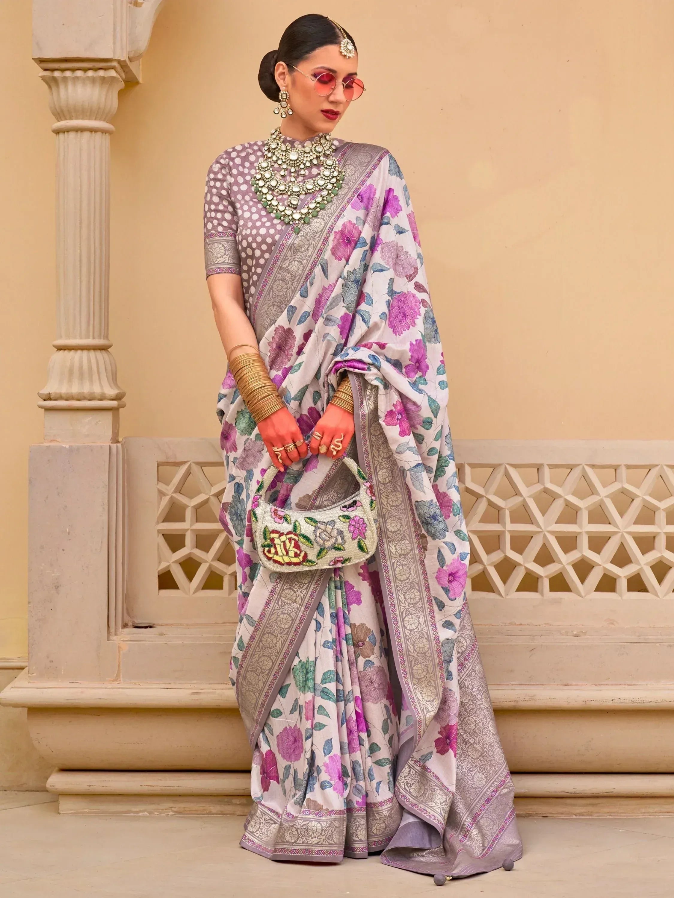 Woman in floral print saree with polka dot blouse, traditional Indian ethnic wear, accessorized with statement jewelry
