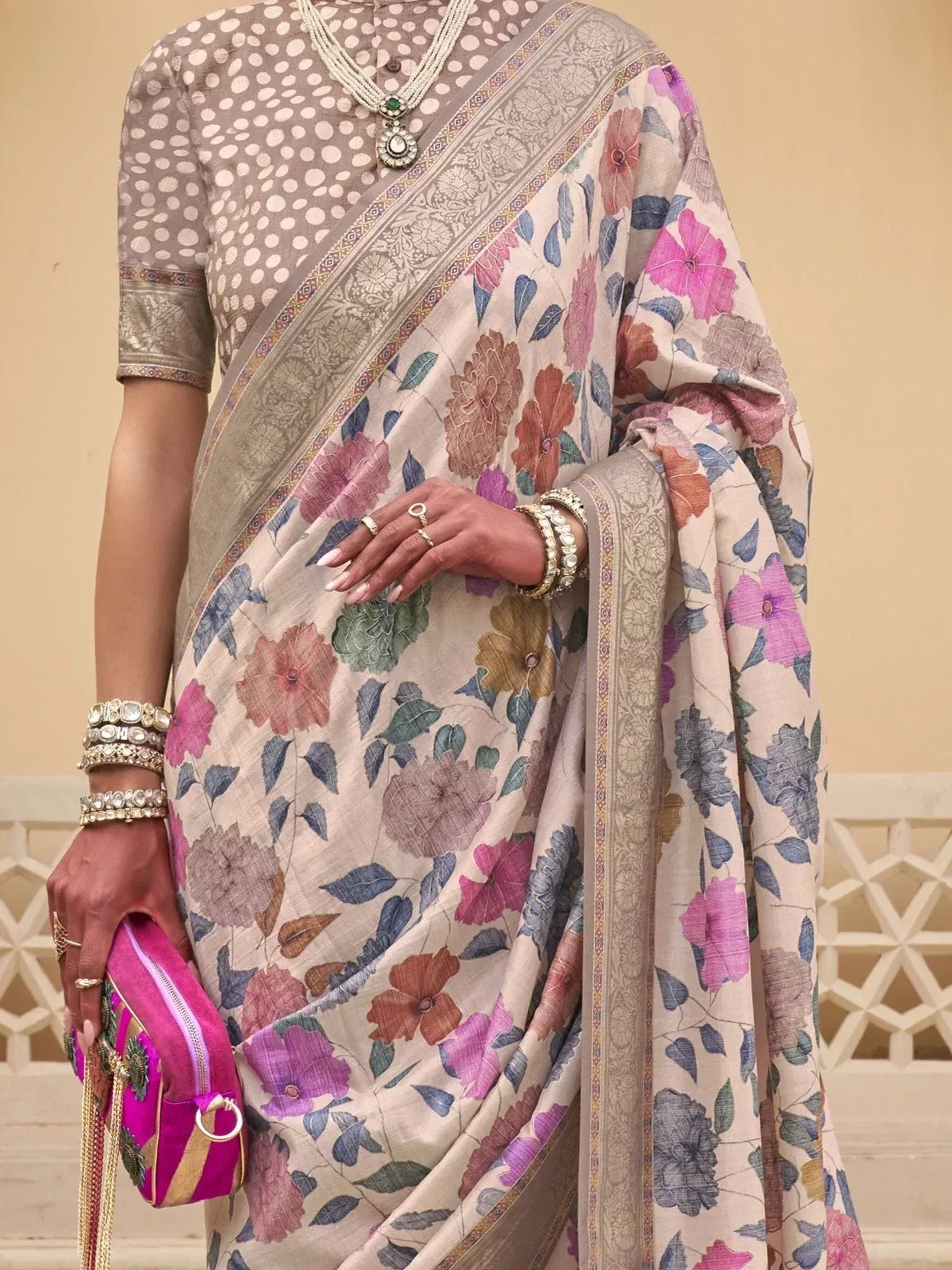 Floral print saree with polka dot blouse, traditional Indian ethnic wear, accessorized with jewelry and clutch