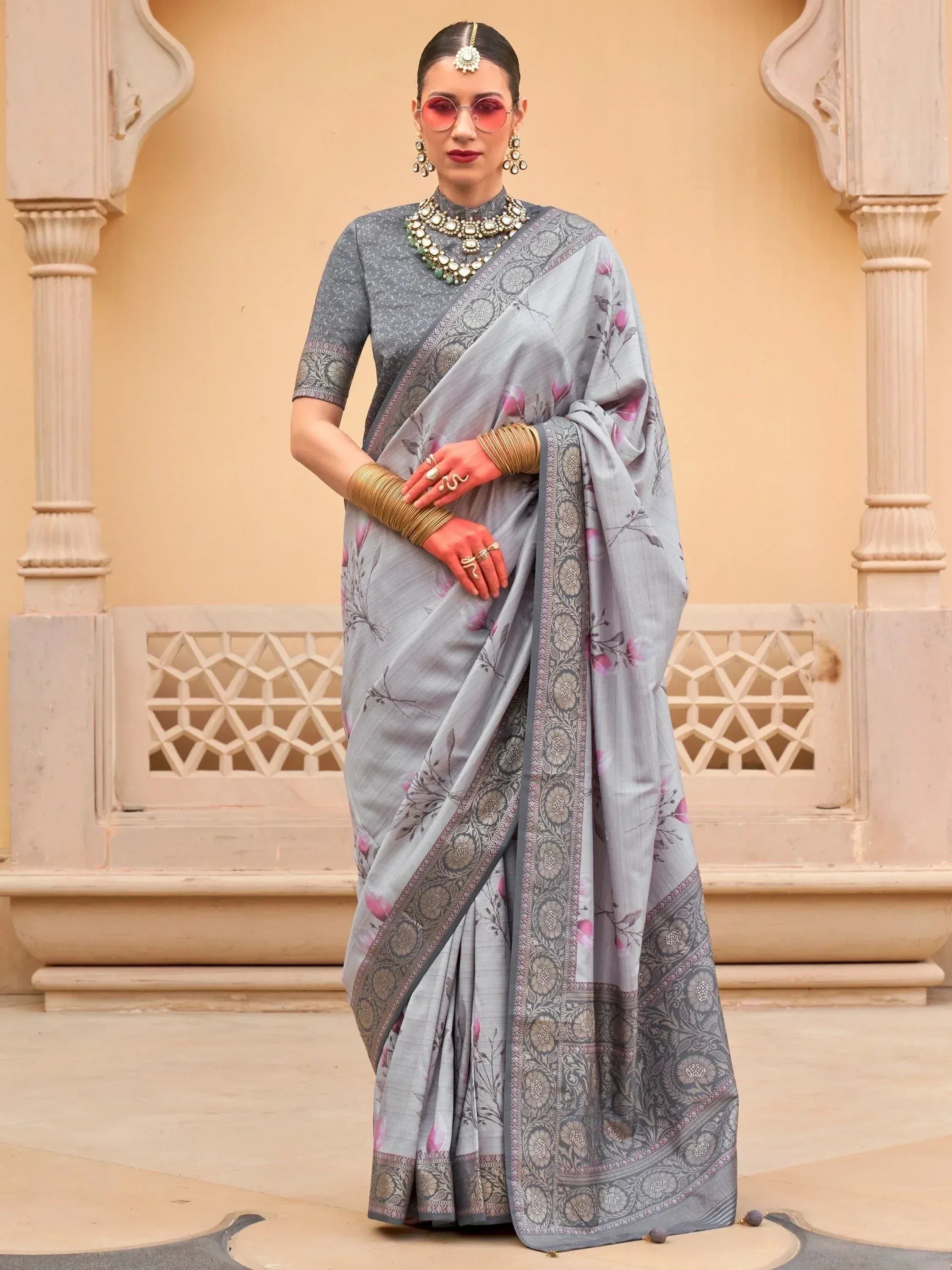 Grey floral saree with intricate border, paired with designer blouse and traditional jewelry for ethnic wear