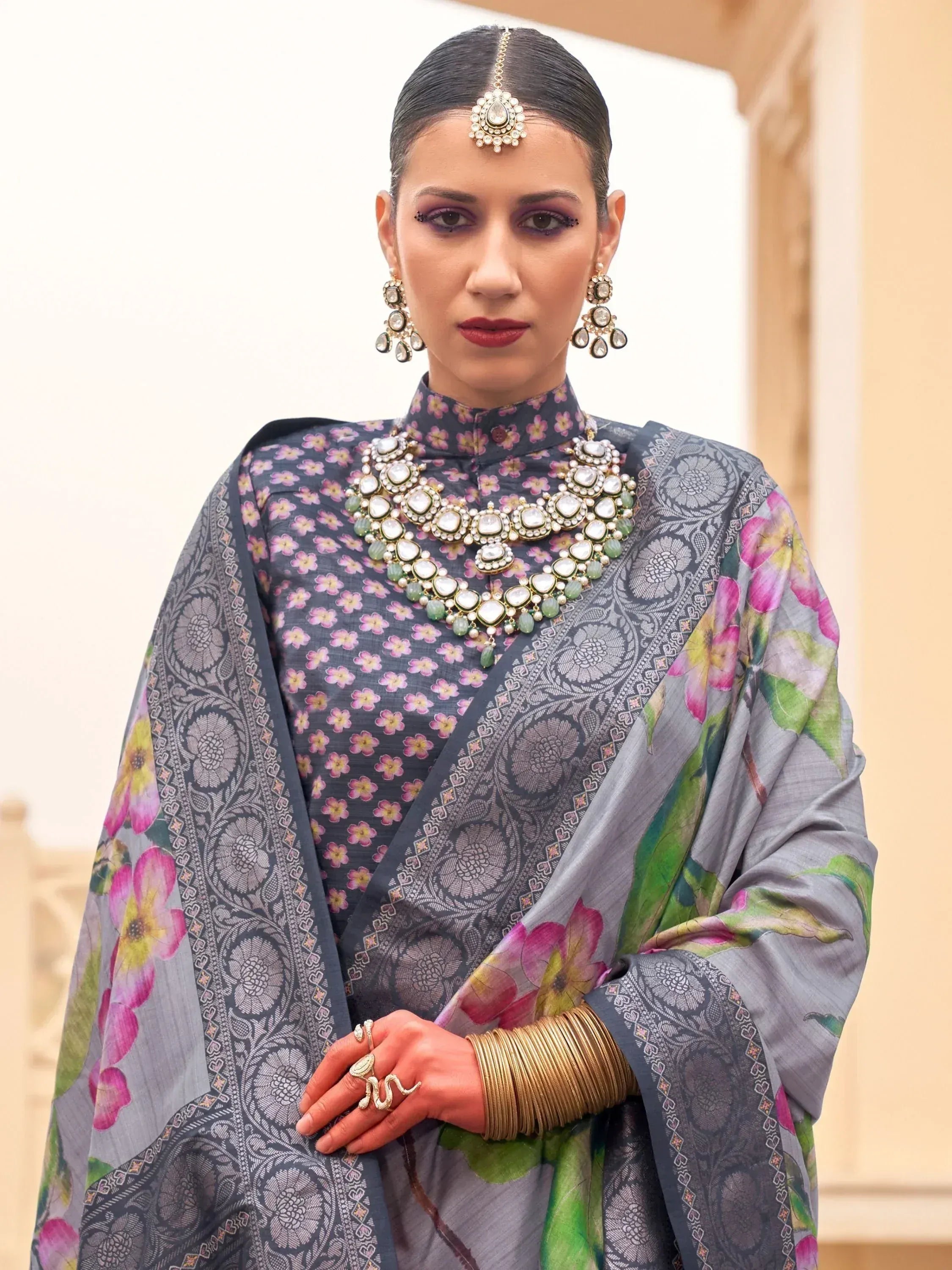 Grey floral printed salwar kameez with intricate dupatta, paired with traditional Indian jewelry for ethnic wear.