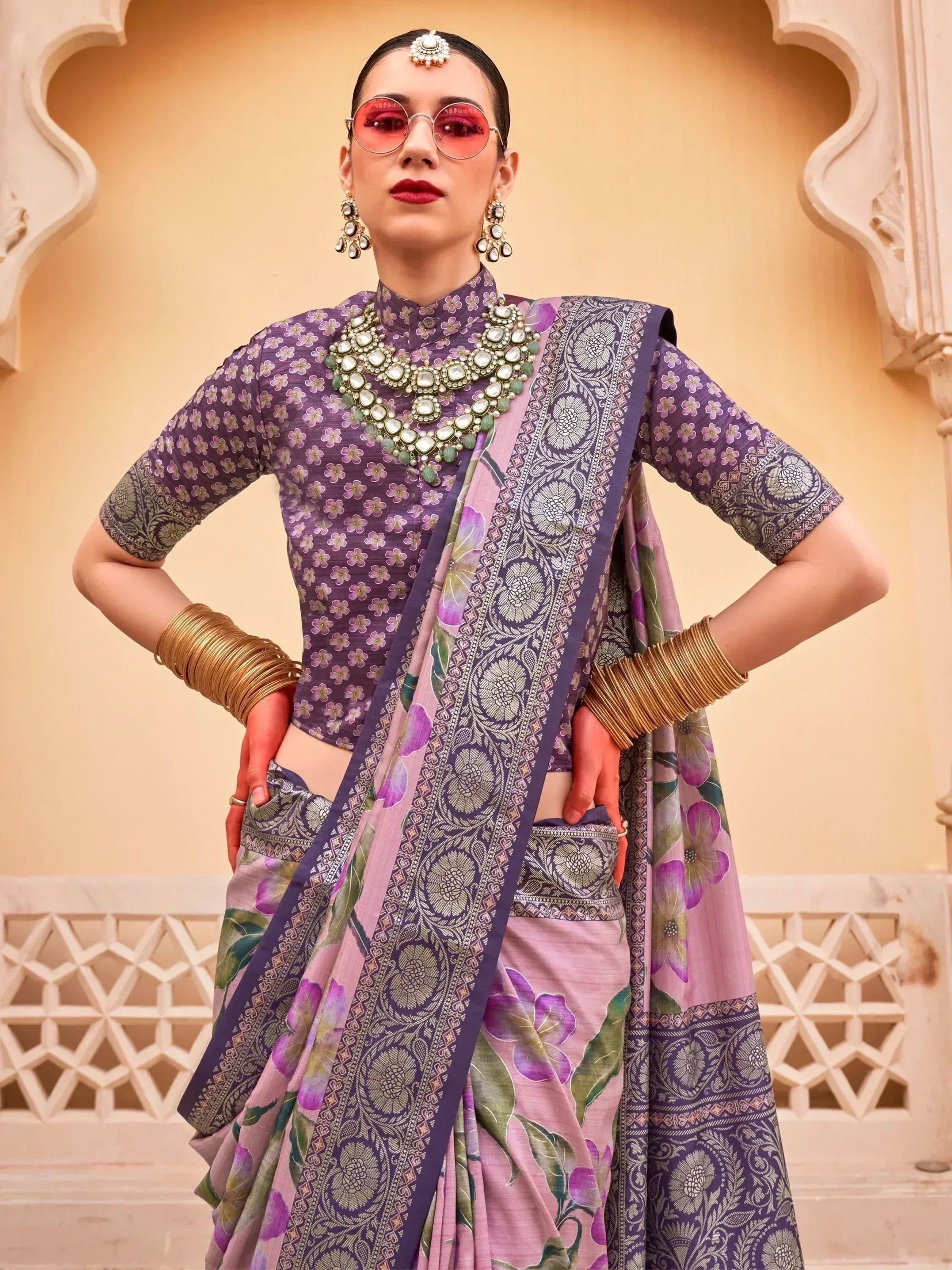 Woman in purple floral printed saree with gold jewelry, styled for Indian ethnic wear
