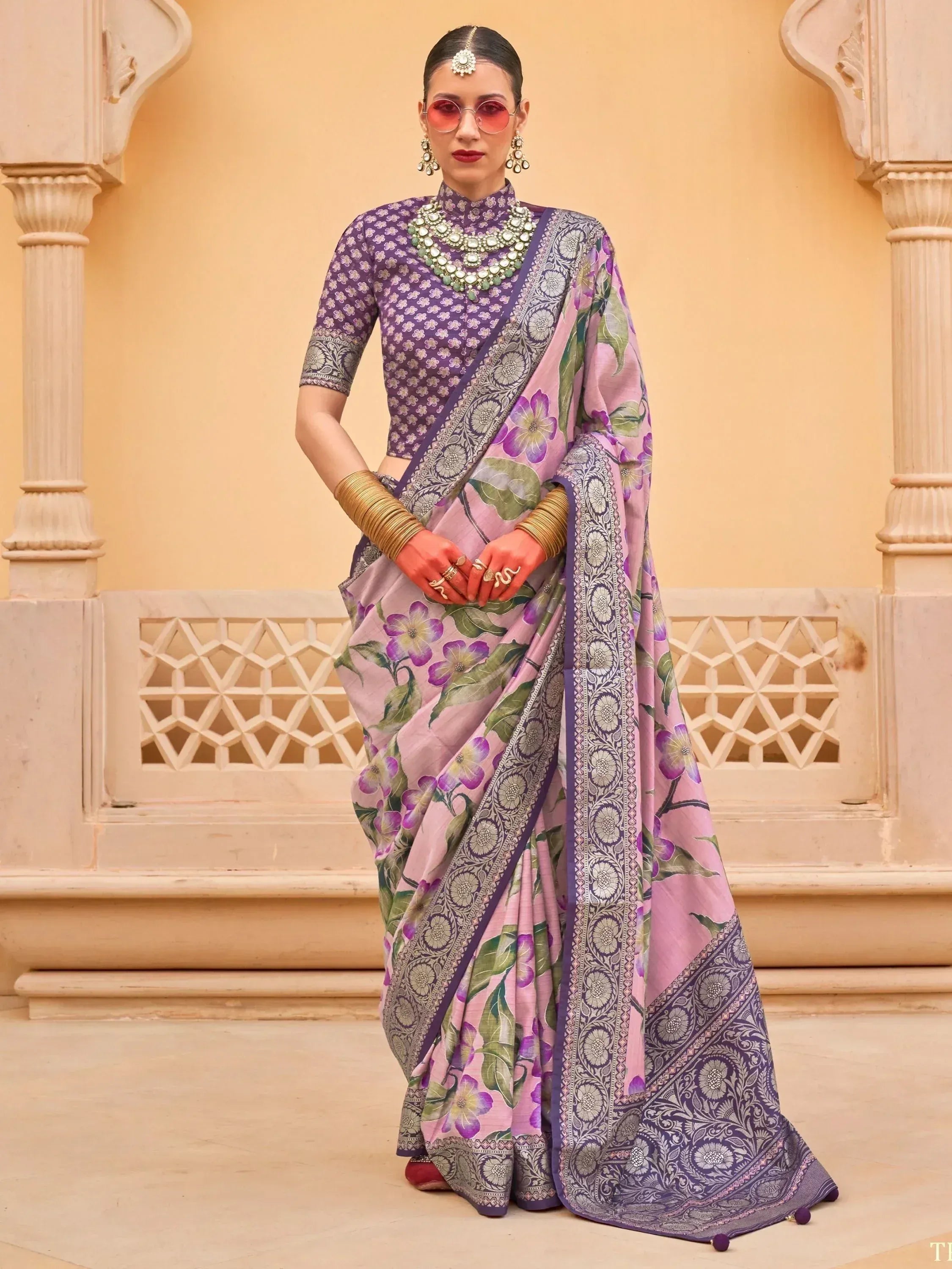 Purple and pink floral saree with intricate border, paired with designer blouse and traditional jewelry for ethnic wear