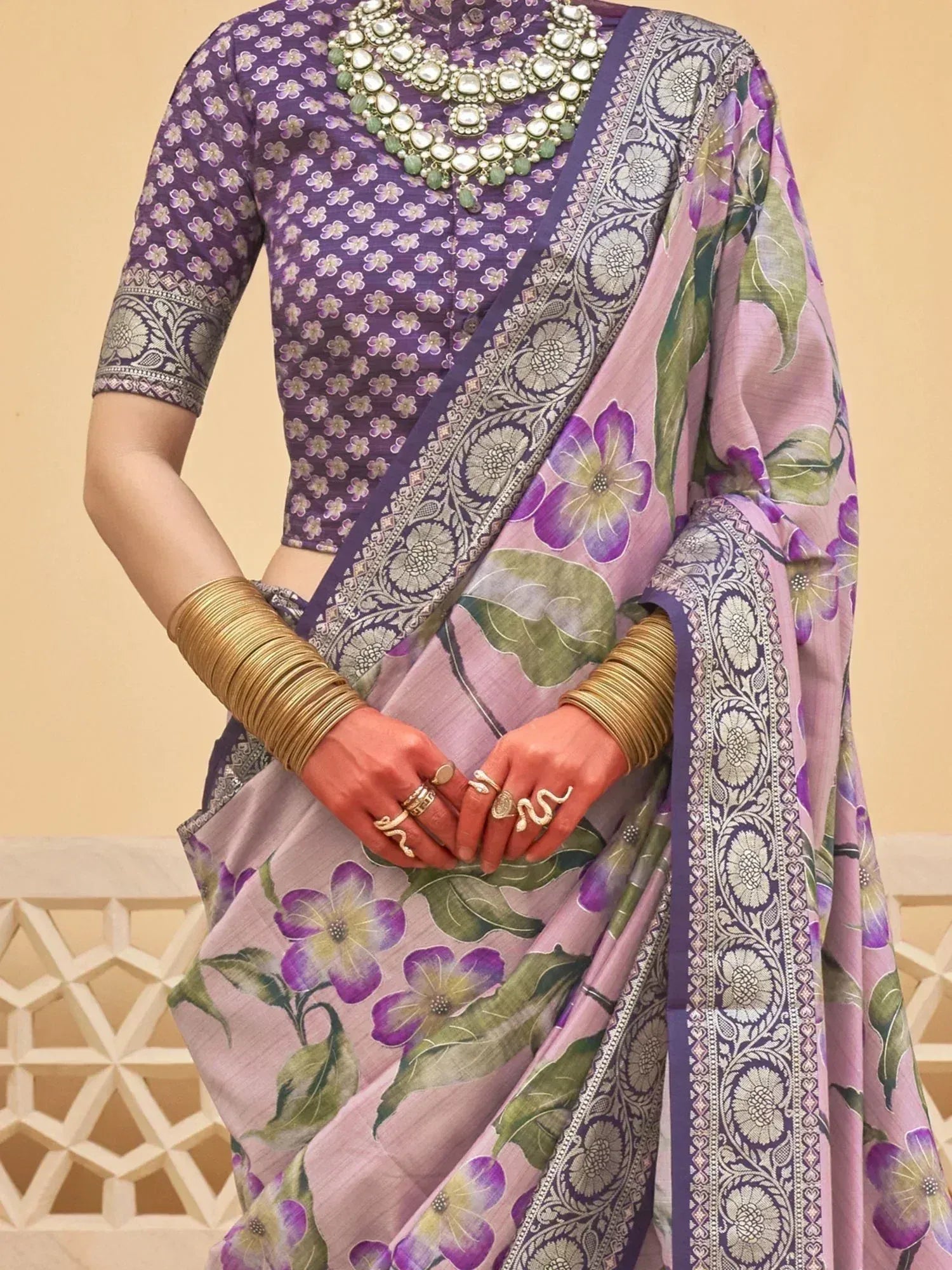 Purple floral saree with designer blouse, ethnic jewelry, and gold bangles for Indian occasions