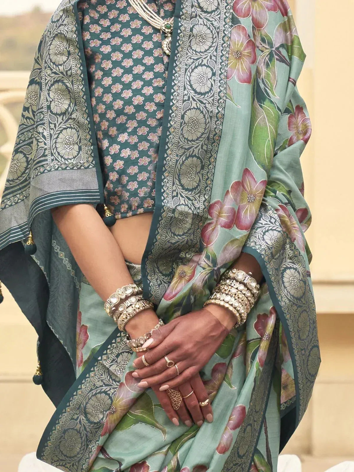 Elegant green floral saree with intricate border, paired with designer blouse and traditional jewelry