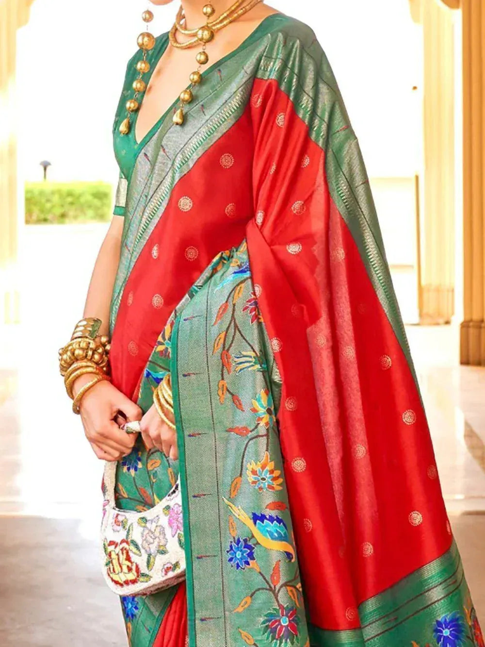 Red and green designer saree with floral embroidery, gold jewelry, and ethnic blouse for Indian occasions