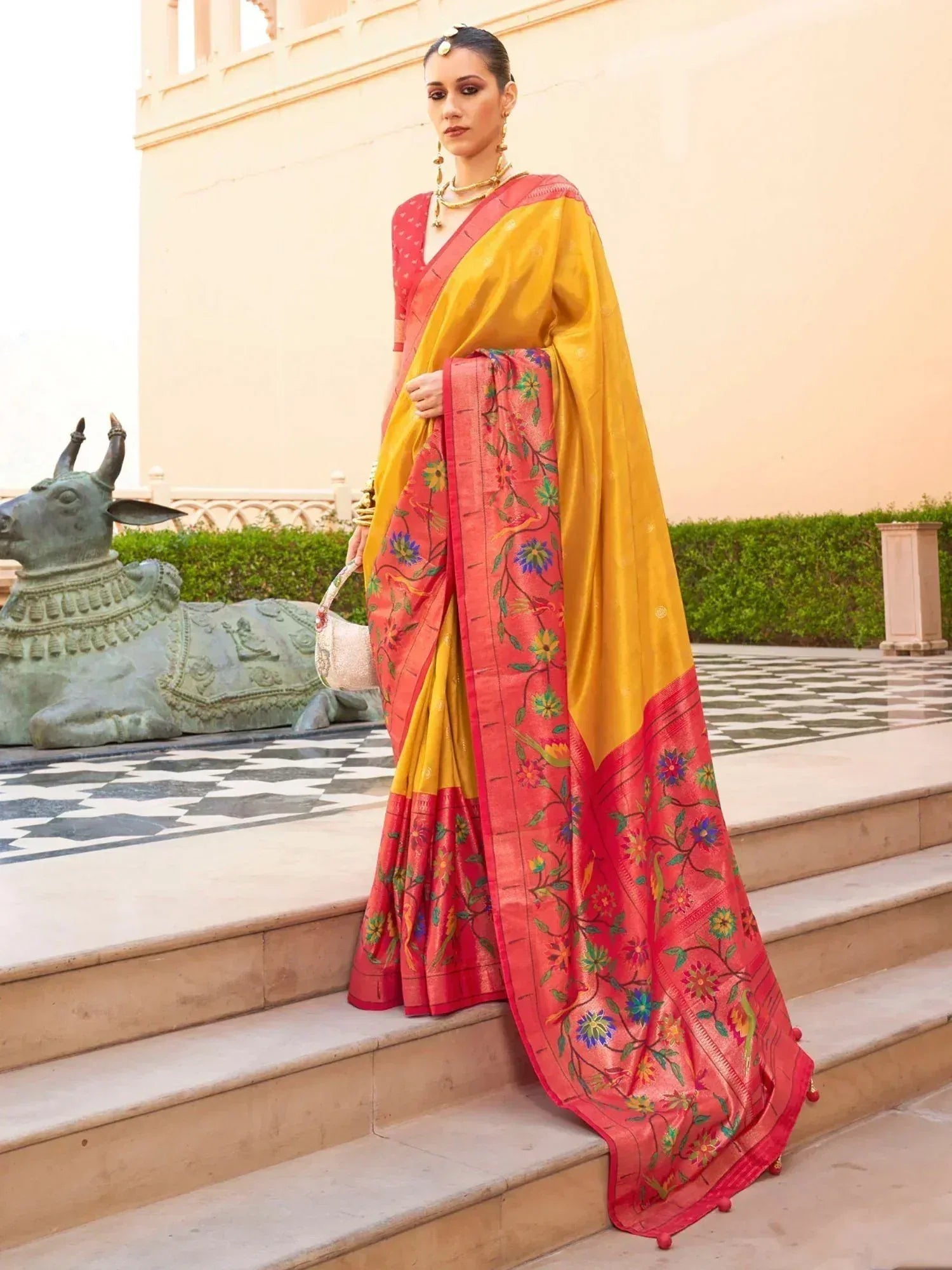 Woman in vibrant yellow and pink floral saree with traditional Indian embroidery, styled for ethnic occasions