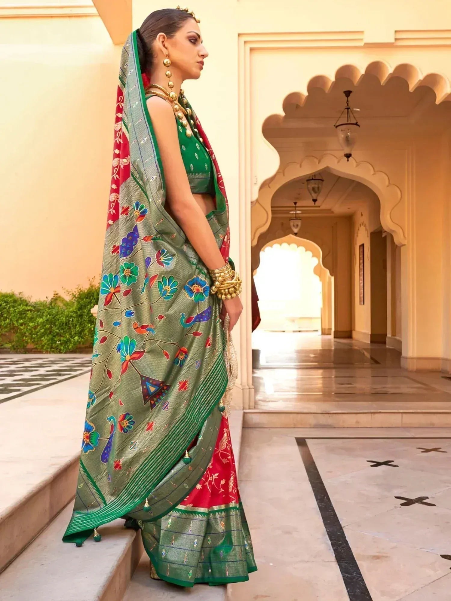 Woman in green and red floral printed saree with peacock motifs, traditional Indian ethnic wear