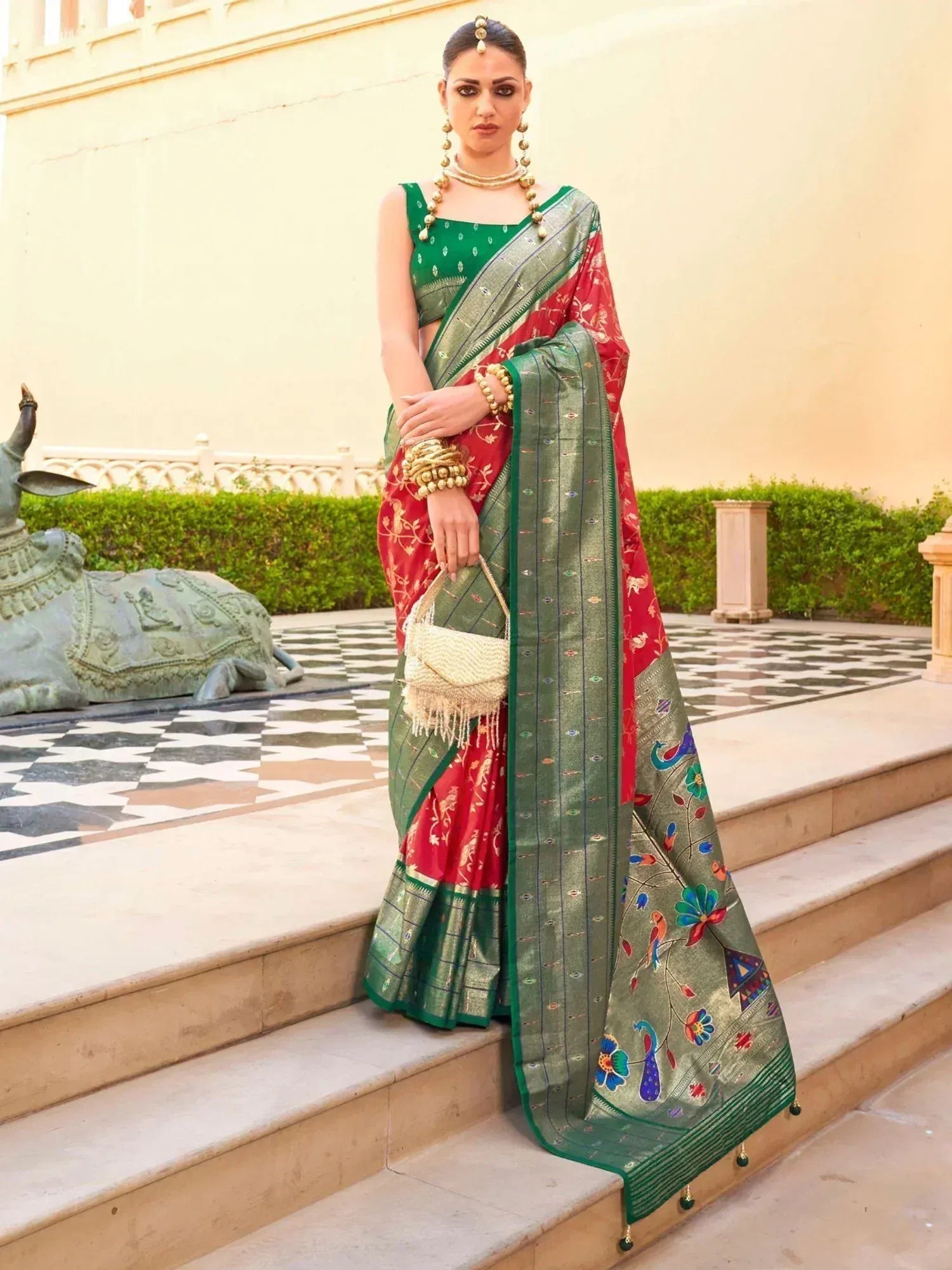 Woman in red and green embroidered saree with peacock motifs, traditional Indian ethnic wear