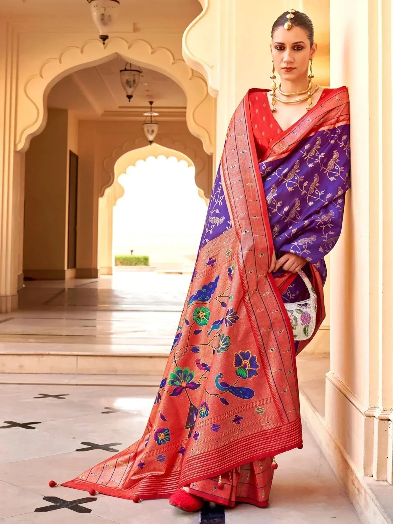 Woman in vibrant purple and red floral saree with peacock motifs, traditional Indian ethnic wear