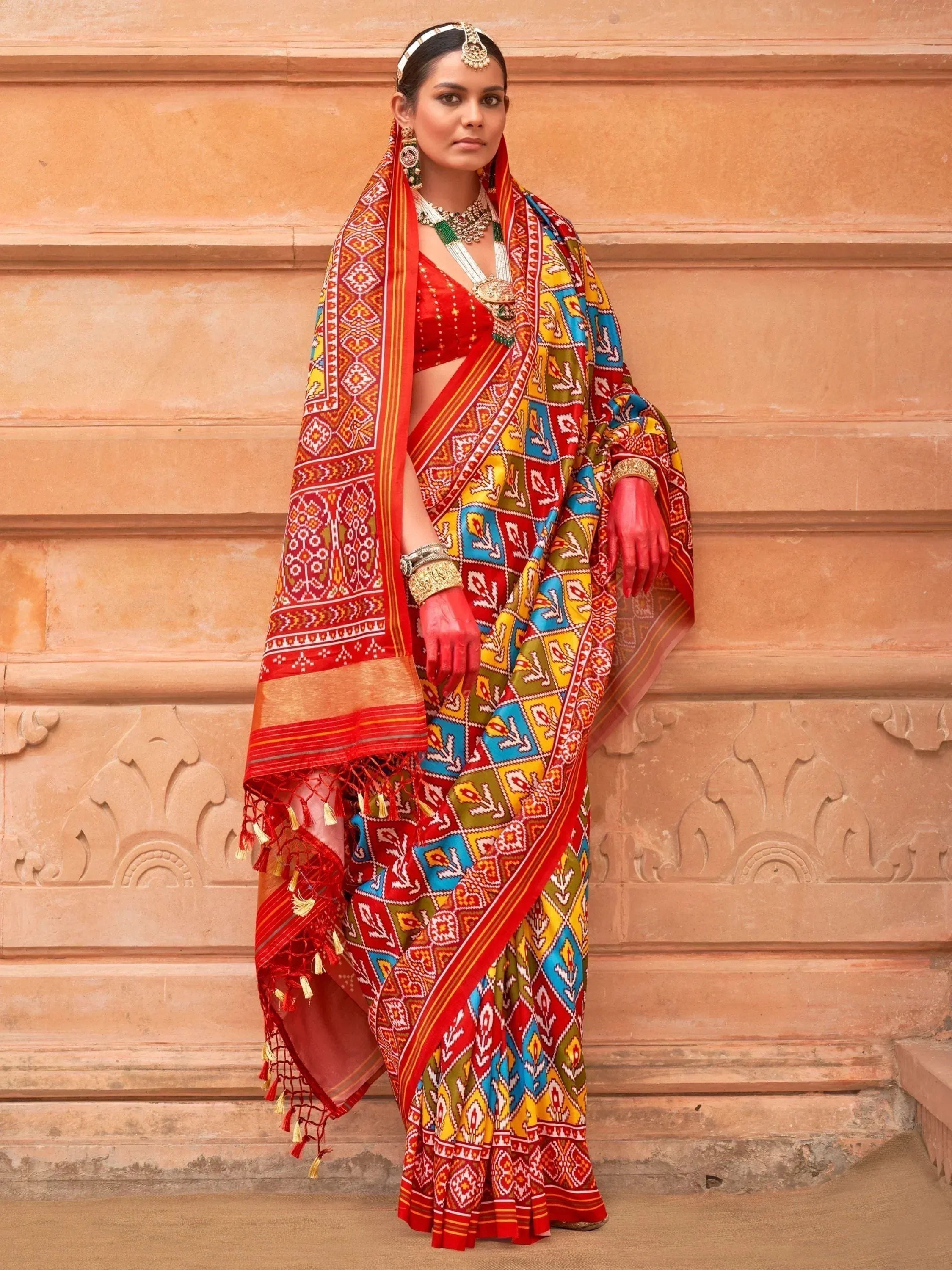 Vibrant red and multicolor printed saree with ethnic jewelry, perfect for Indian festivals and weddings.