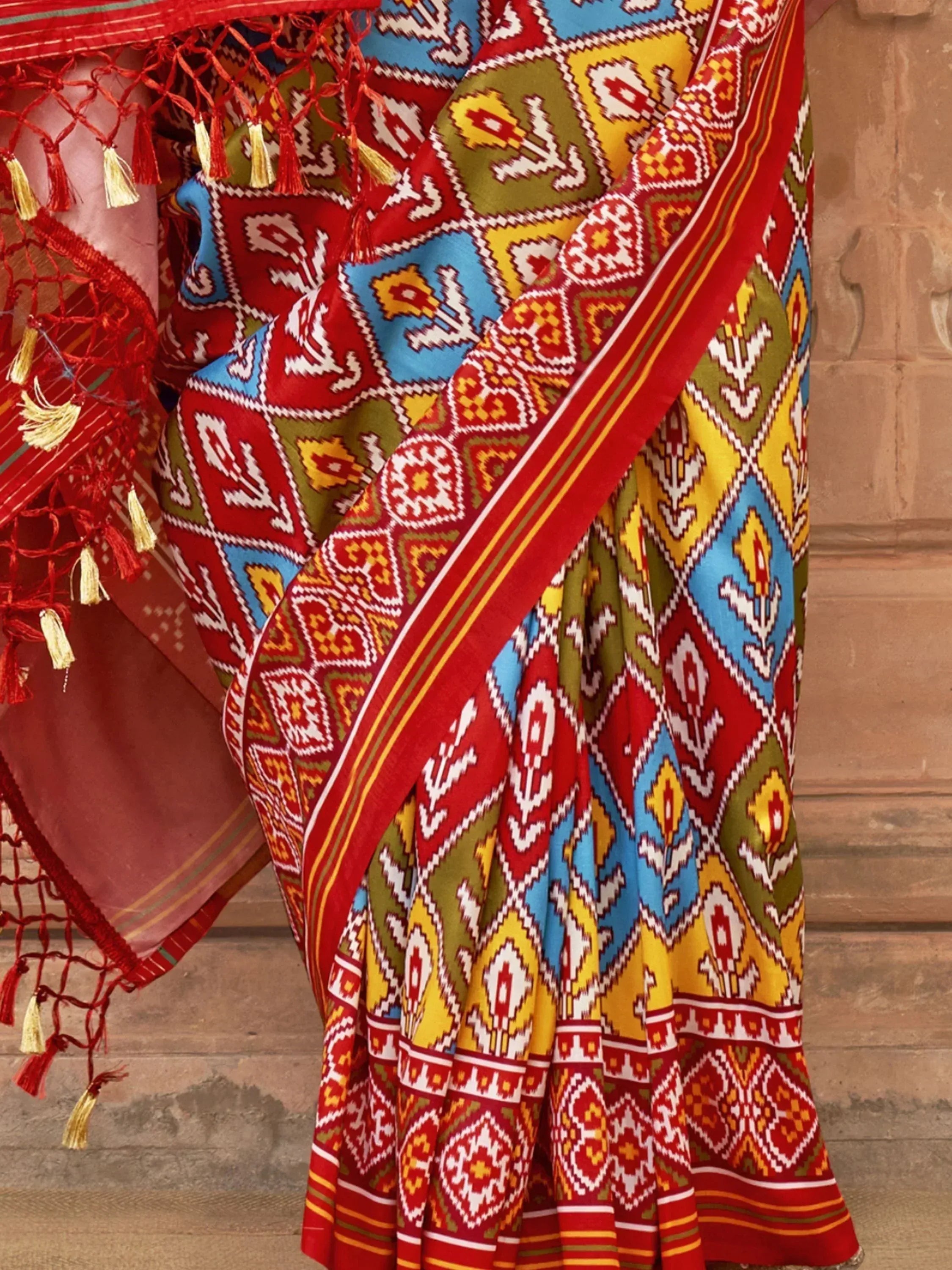 Vibrant ethnic saree with geometric patterns and tassel border, perfect for Indian festive wear