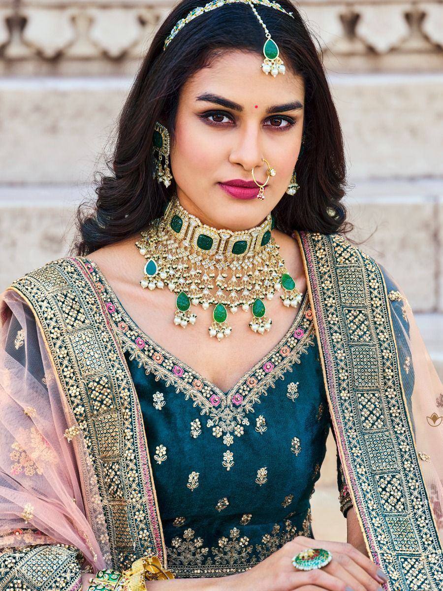 Elegant Indian ethnic wear with emerald jewelry, designer blouse, and embroidered dupatta for festive occasions.