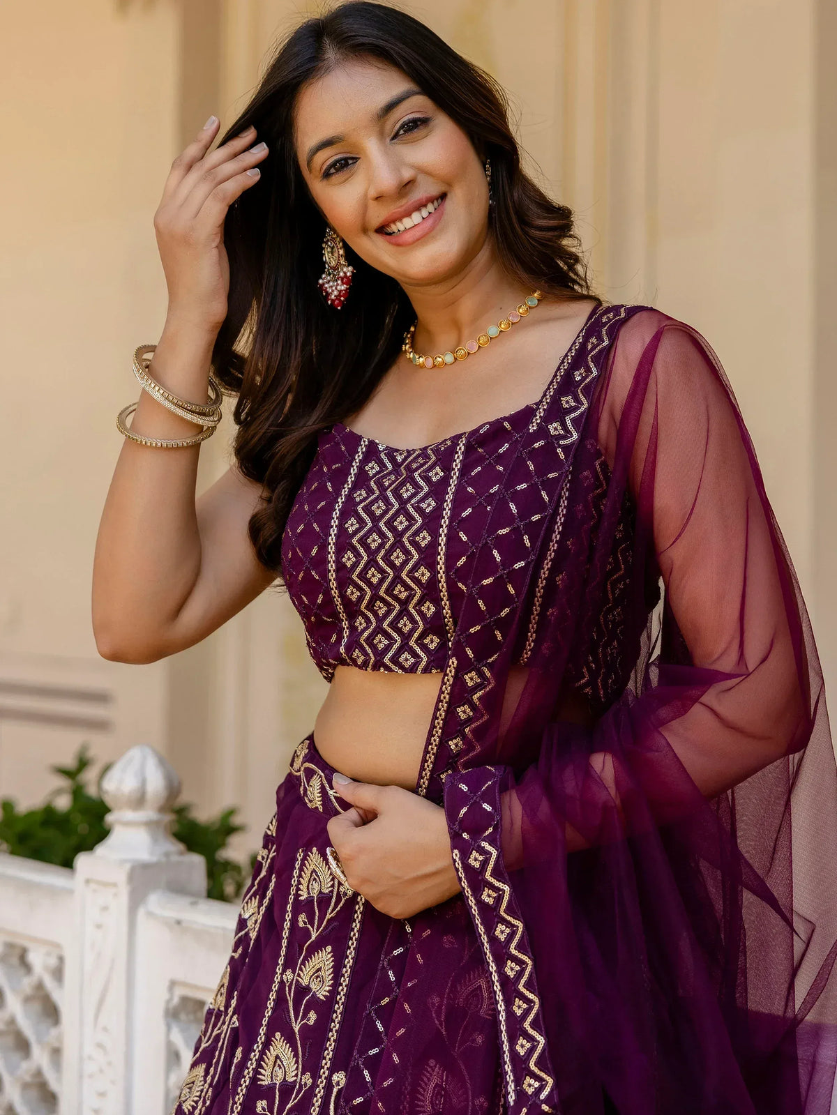 Woman in purple embroidered lehenga choli with gold detailing and sheer dupatta, perfect for Indian ethnic wear occasions