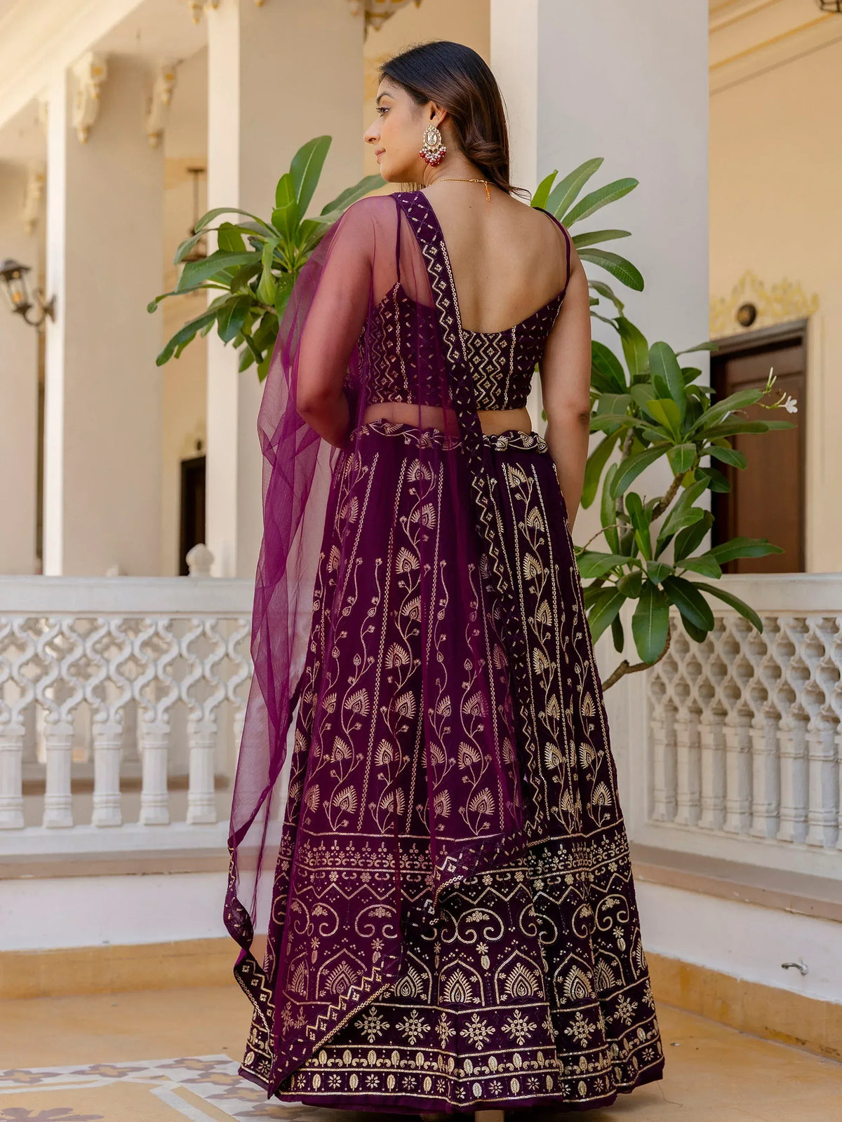 Purple embroidered lehenga choli with gold detailing, sheer dupatta, and open back design