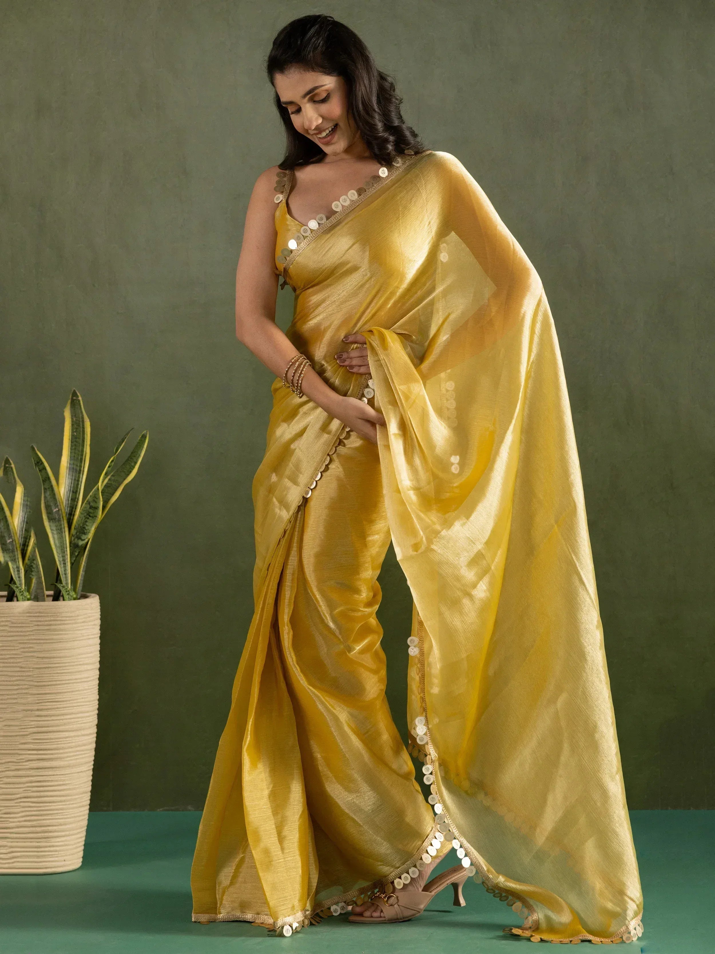 Yellow ethnic saree with coin embellishments, perfect for Indian festive occasions and designer wear.