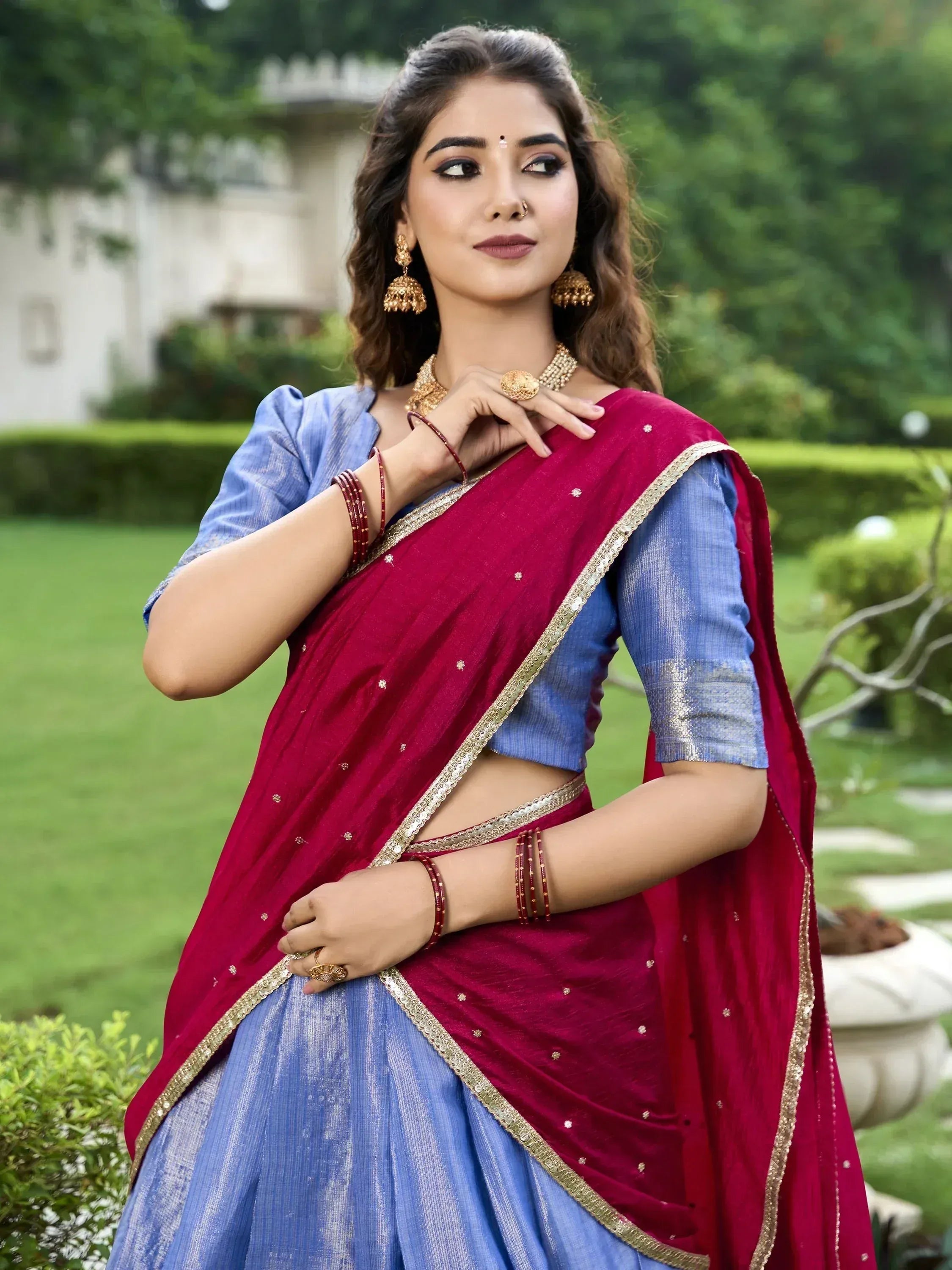 Woman in maroon and blue designer lehenga choli with gold embroidery, perfect for Indian ethnic wear occasions