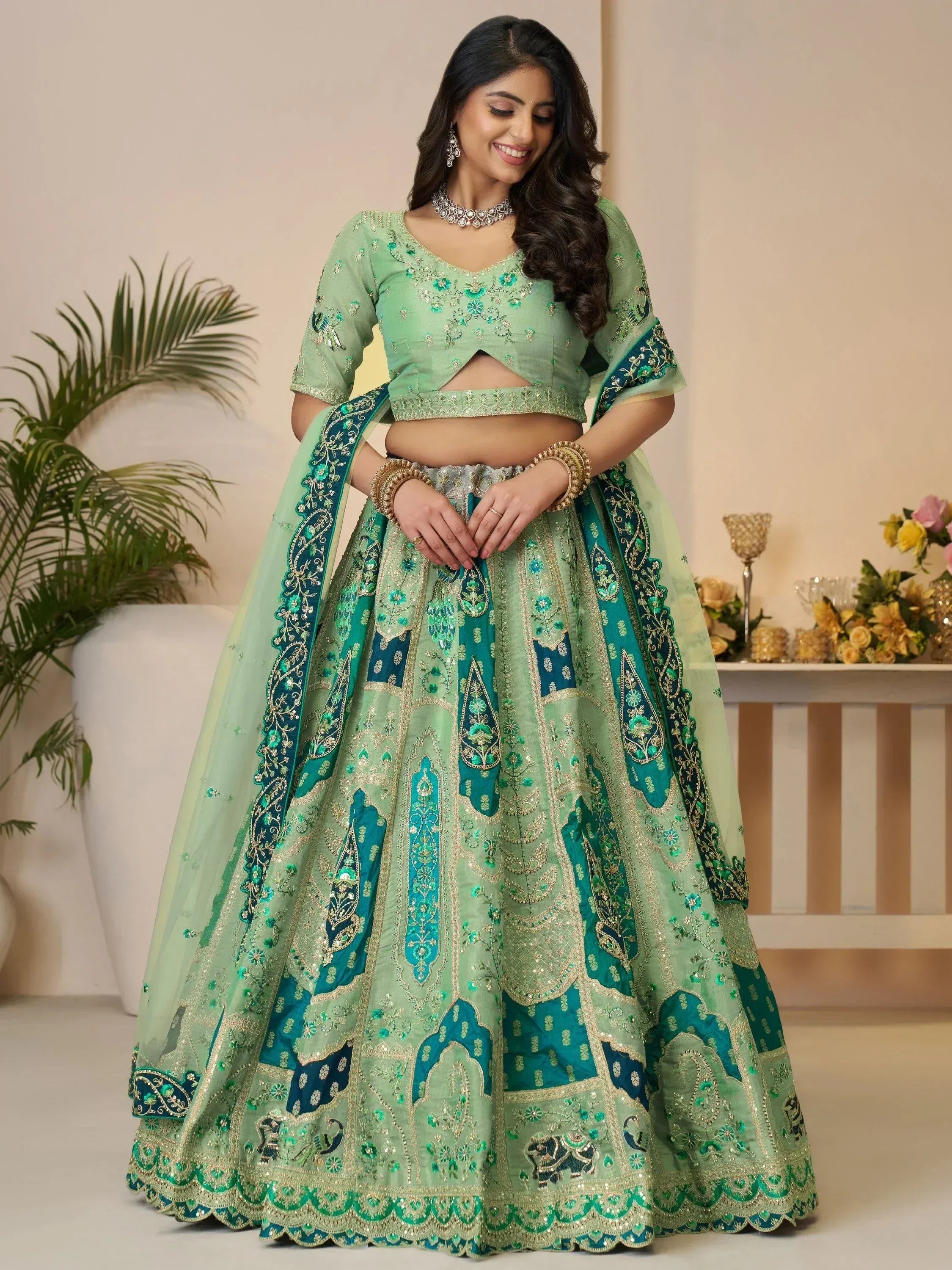 Green embroidered lehenga choli with floral and paisley designs, perfect for Indian weddings and festive occasions.