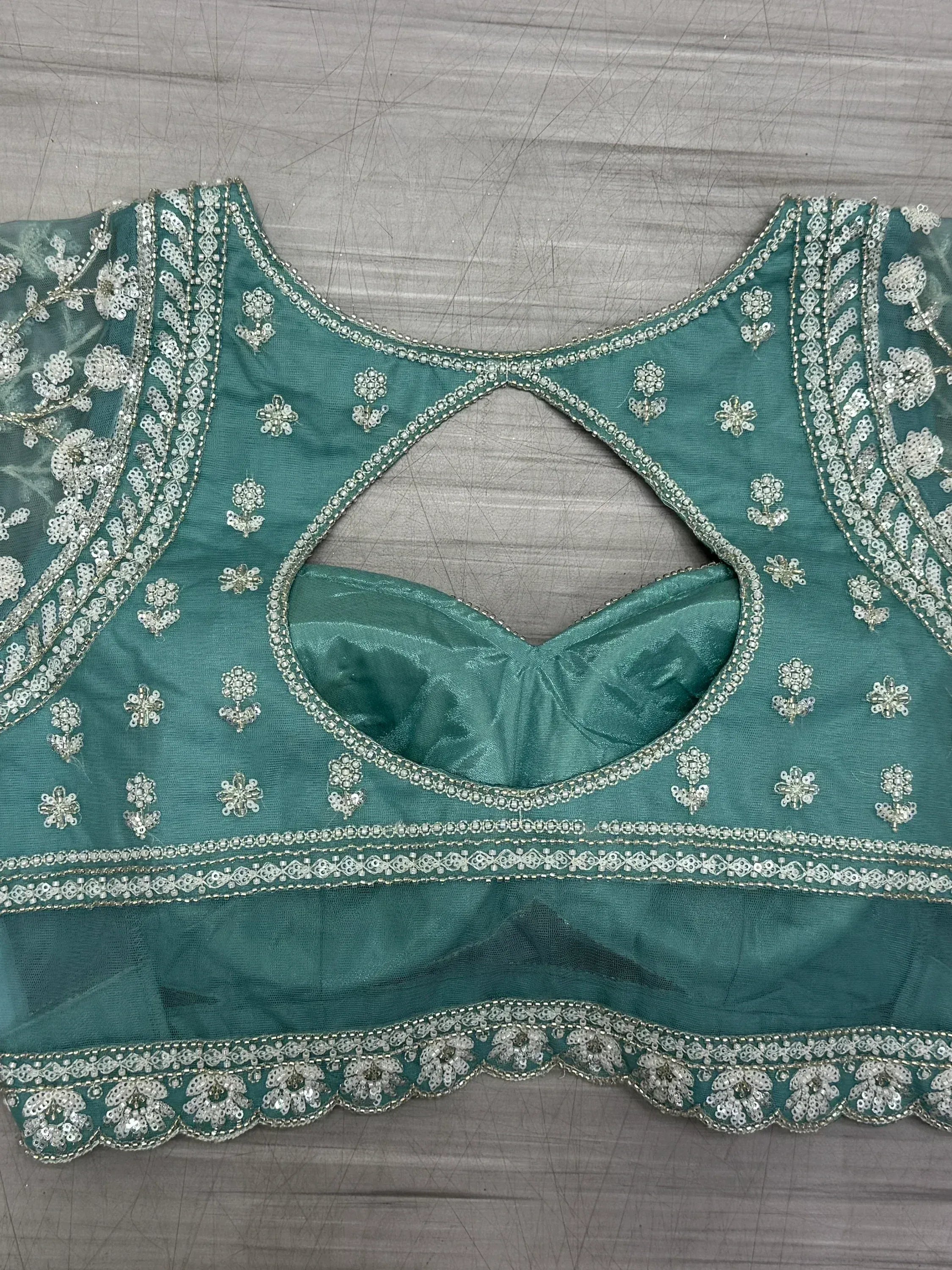 Teal green embroidered blouse with silver floral sequin work and keyhole back, ideal for lehenga choli