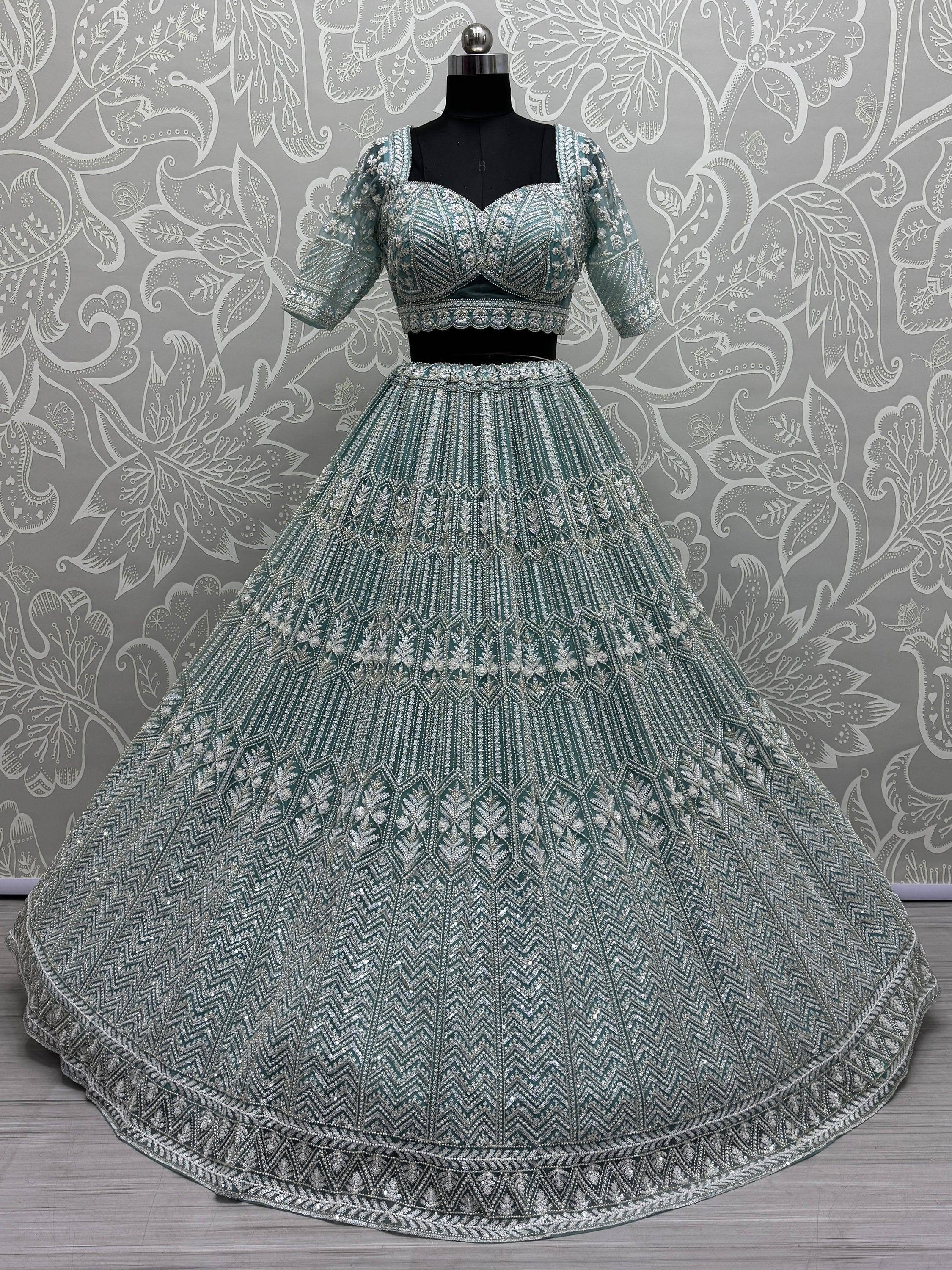 Teal designer lehenga choli with heavy silver embroidery, perfect for Indian weddings and festive occasions.