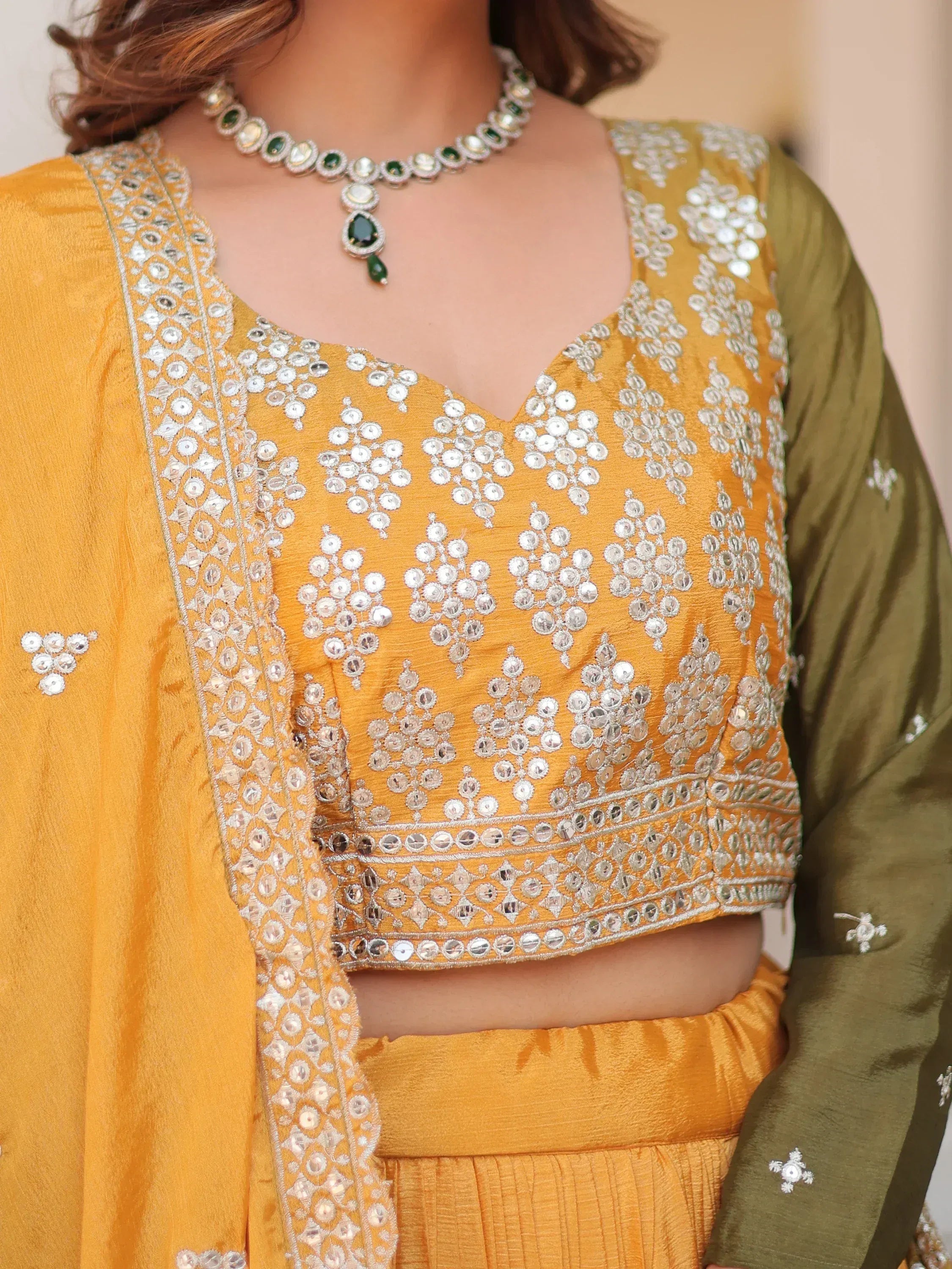 Yellow ethnic crop top with mirror work and green dupatta, paired with matching skirt and jewelry